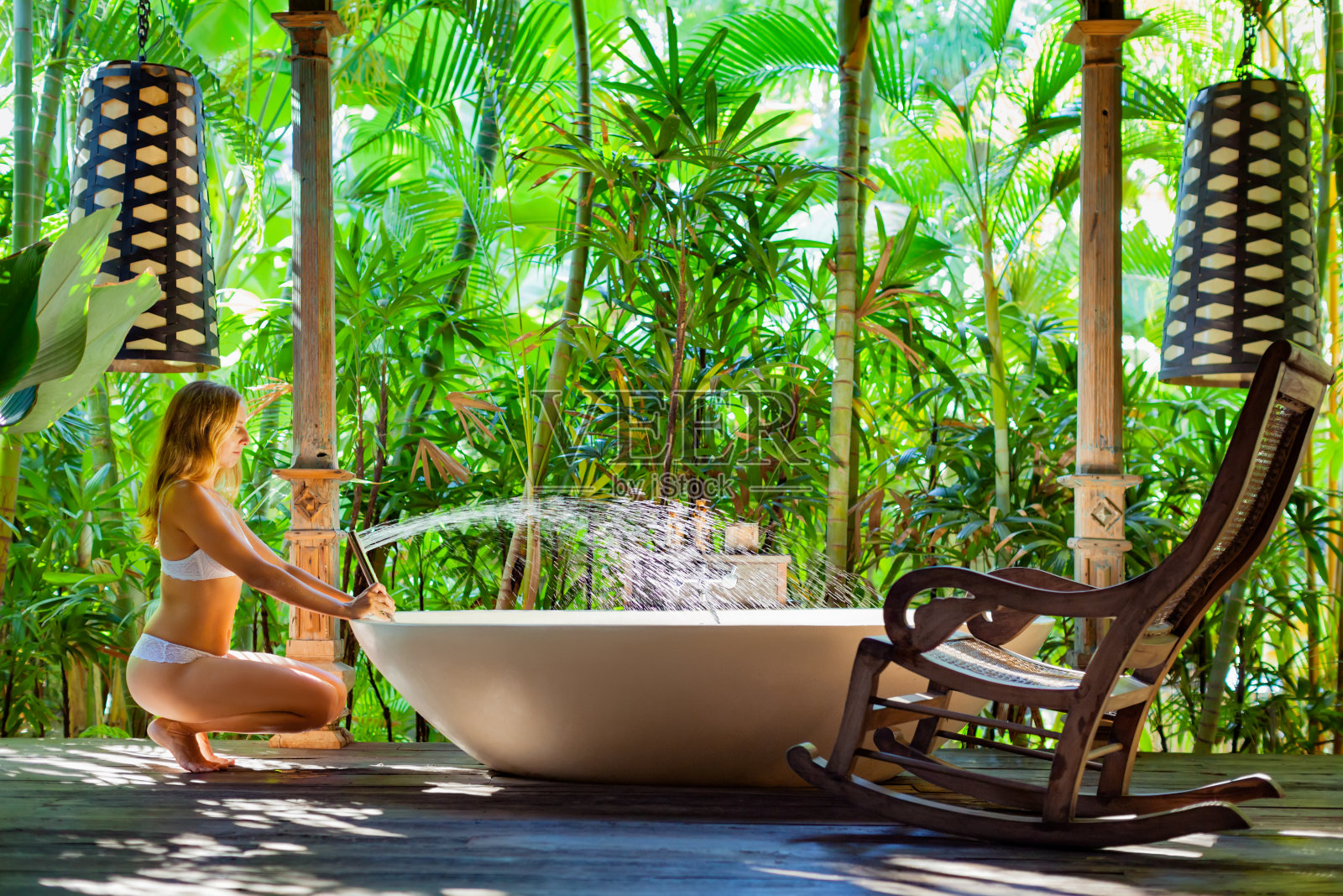 女人在沐浴与花园的露天阳台照片摄影图片