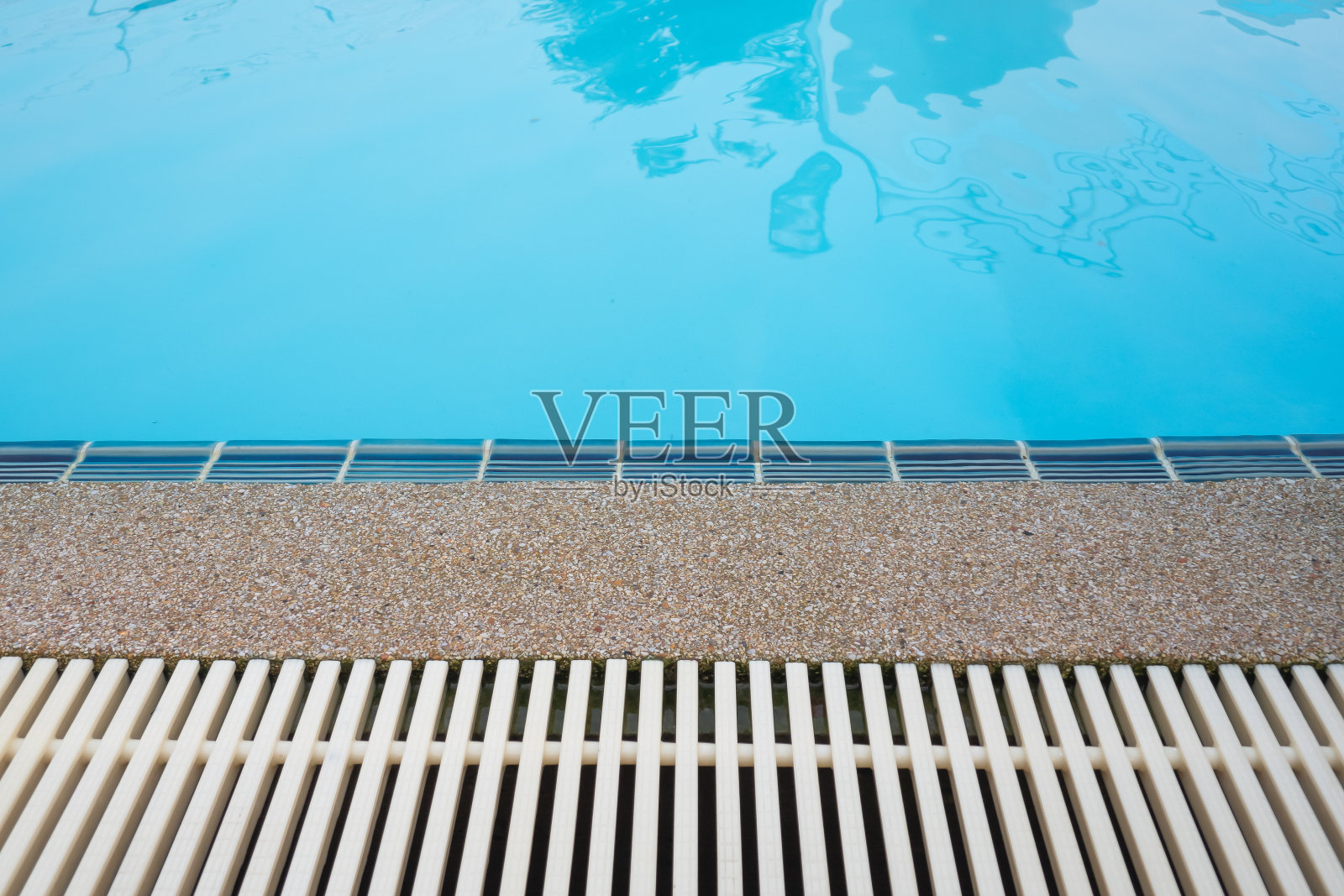 游泳池溢排水格栅,池水清澈碧蓝。格栅采用塑料材料制成,耐热防震,防滑,长期使用不脏。照片摄影图片