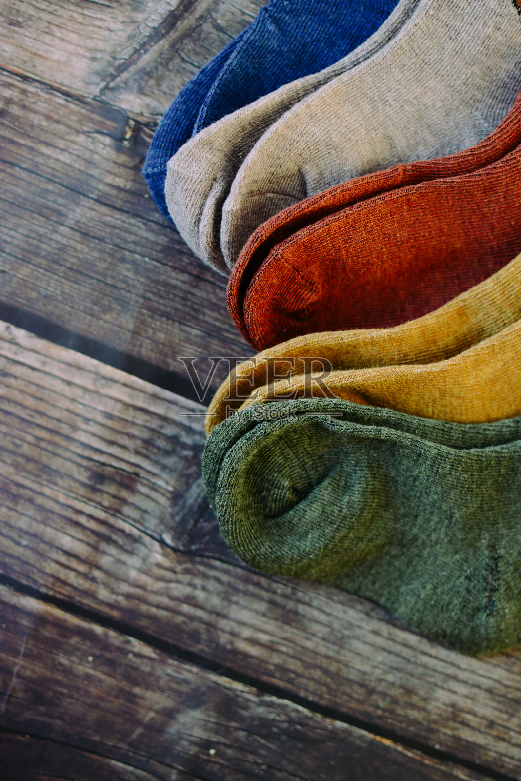 黑色木制背景上的彩色小婴儿袜照片摄影图片