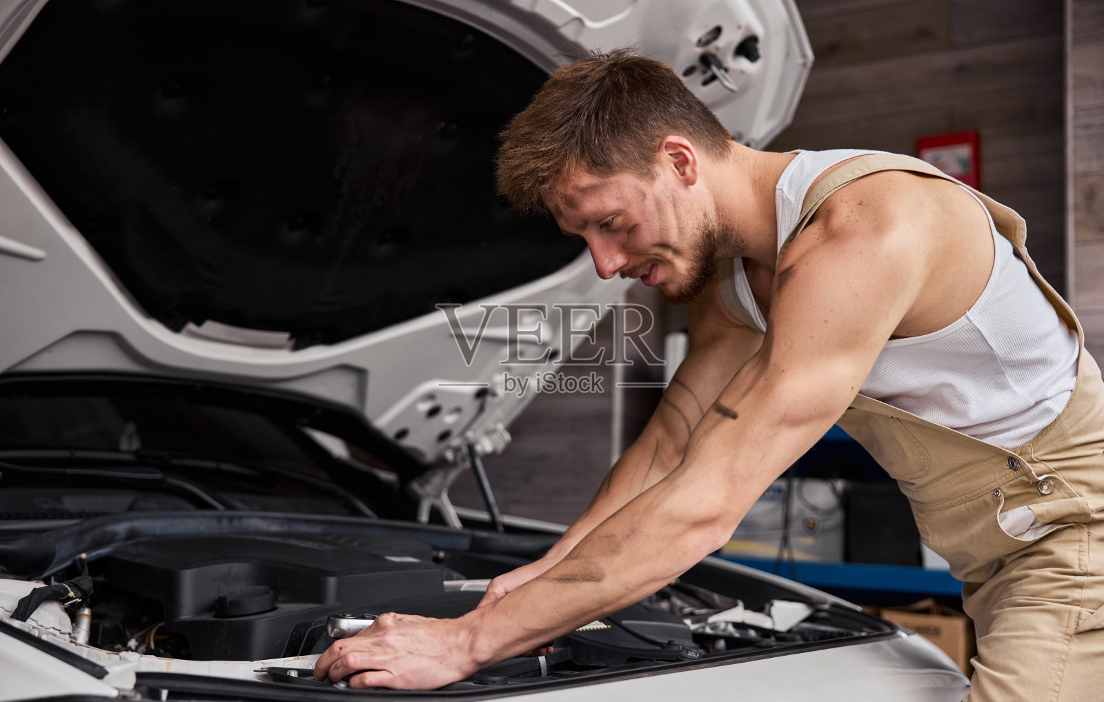 一个修理工在他的车库里工作的肖像。照片摄影图片