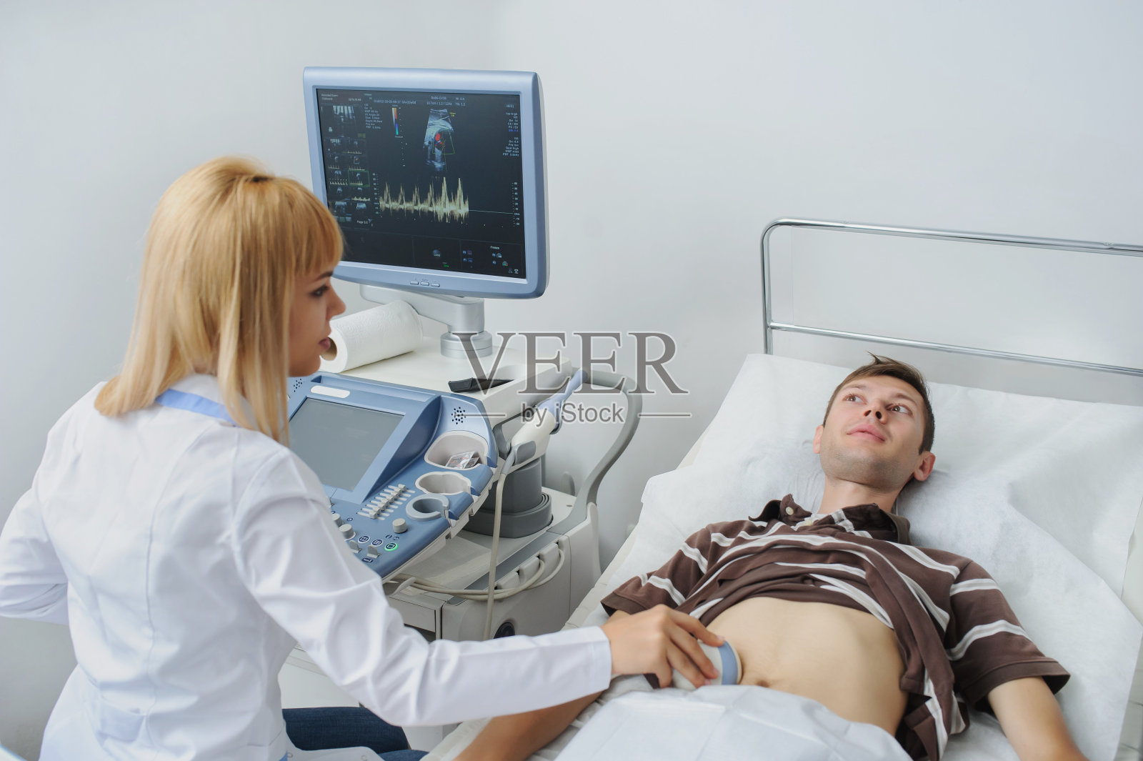 医生在检查一个男人的腹部照片摄影图片