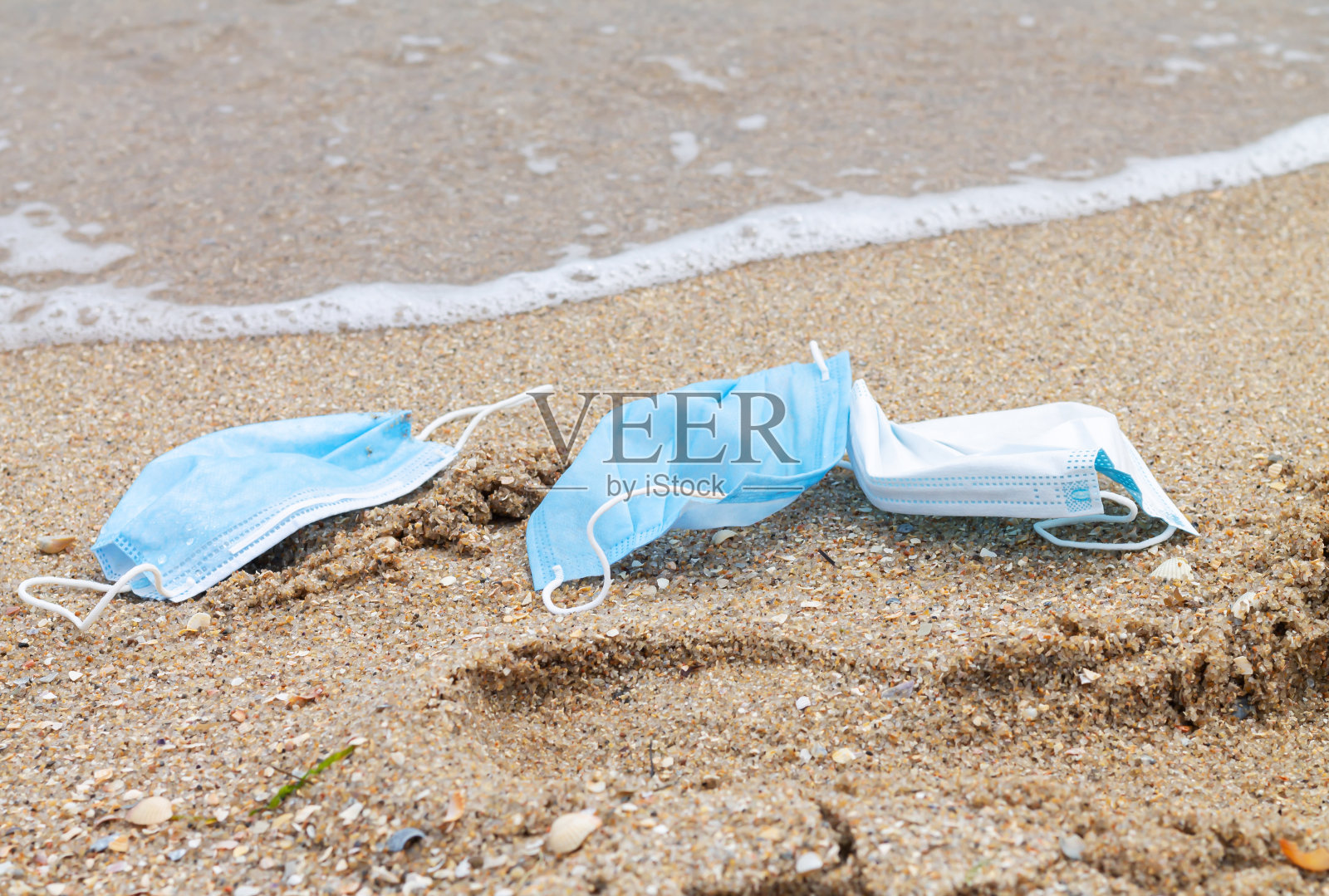 使用过的防护口罩被丢弃到海洋,海洋塑料污染的概念照片摄影图片