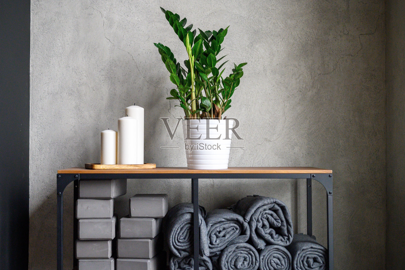 房间的内部是运动瑜伽或伸展的工作室。表架与附件类-灰色支持立方体,橡胶垫和格子。装饰蜡烛和zamioculcas zamiifolia植物照片摄影图片