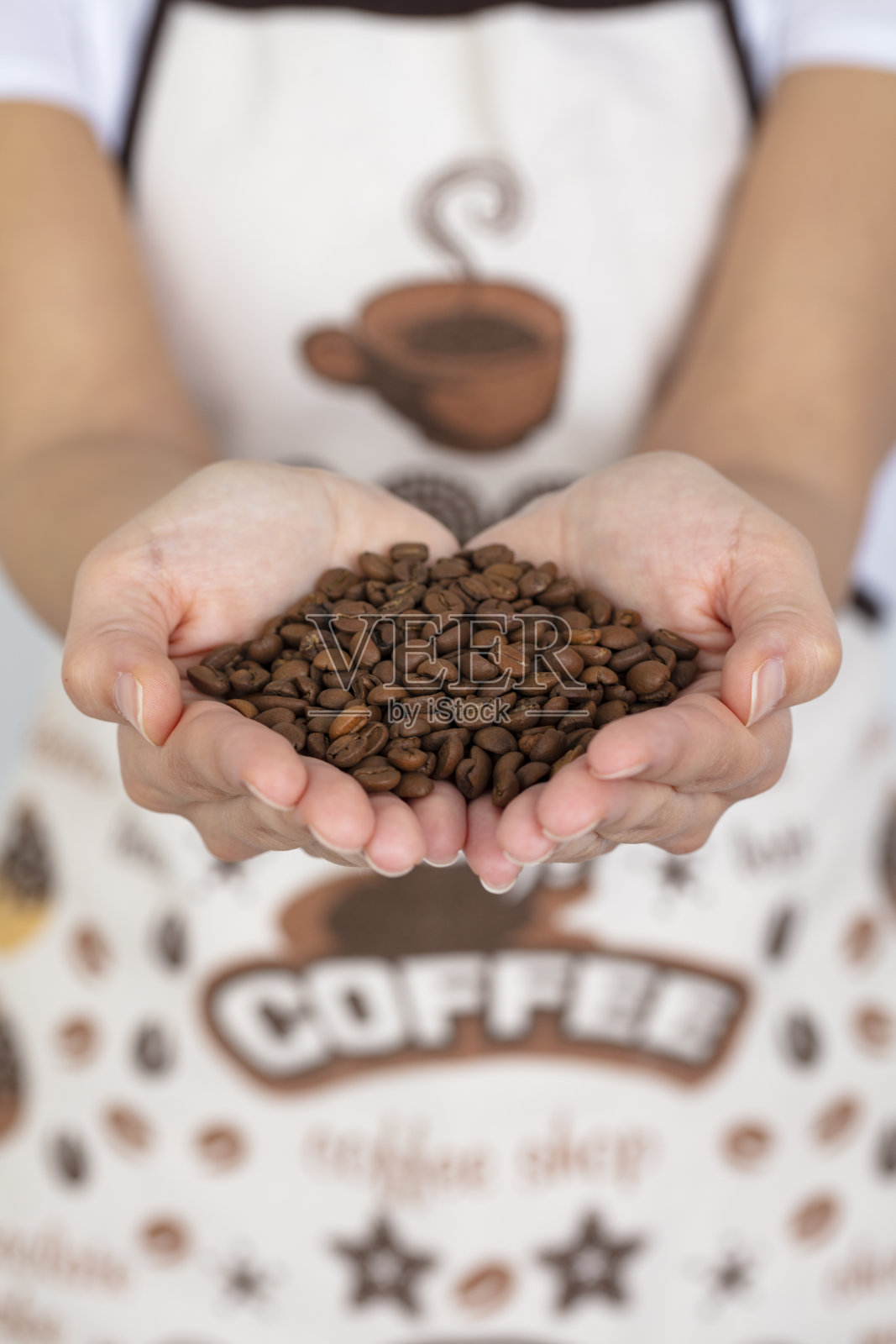 在女性手中烘焙咖啡豆,近距离,孤立。照片摄影图片
