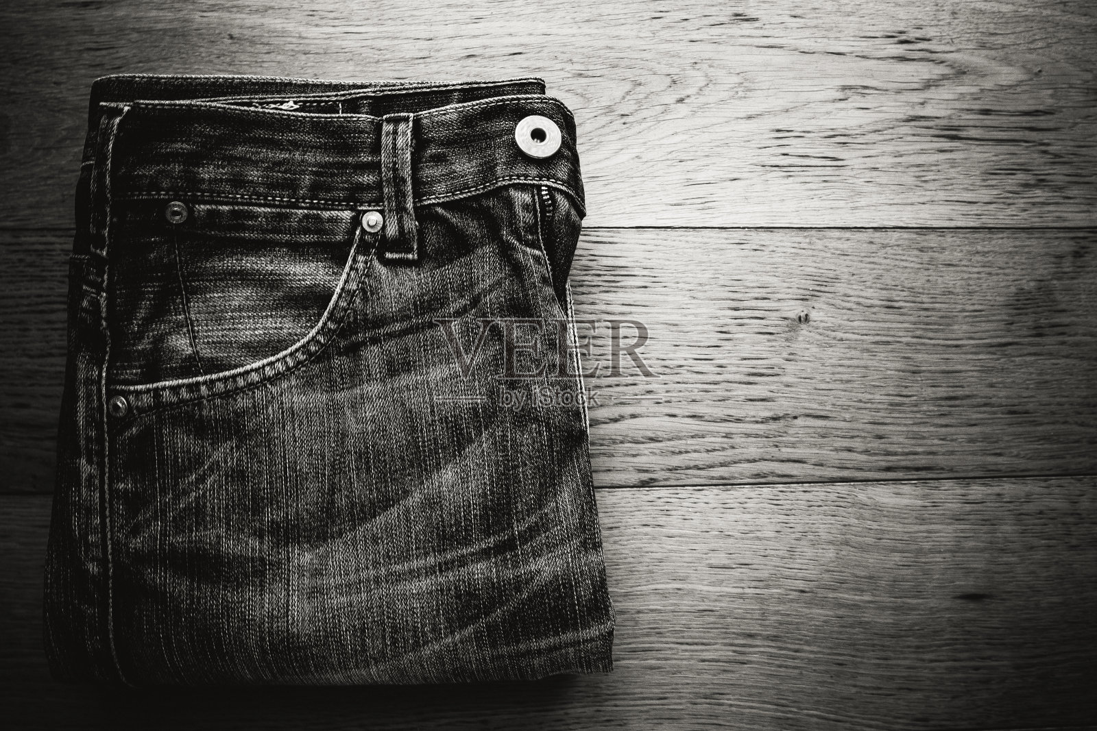 牛仔牛仔裤折叠在木桌上照片摄影图片