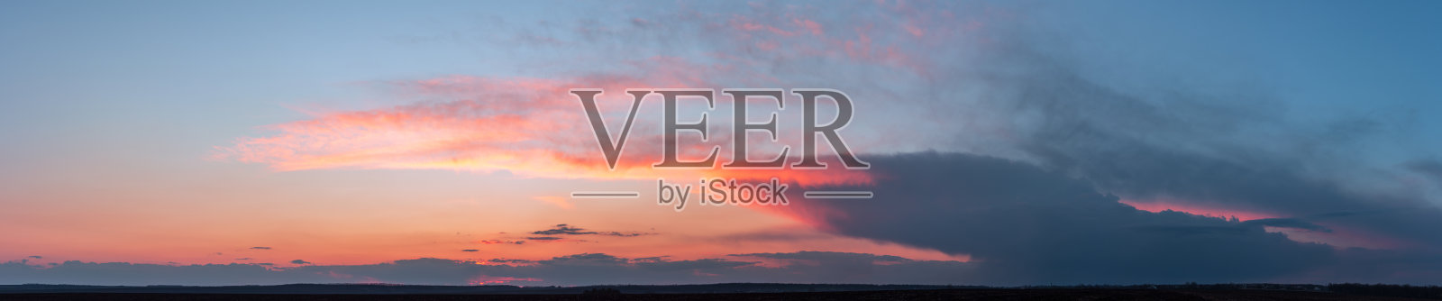 戏剧性的阴郁全景,明亮的饱和日落与黑暗的云照片摄影图片