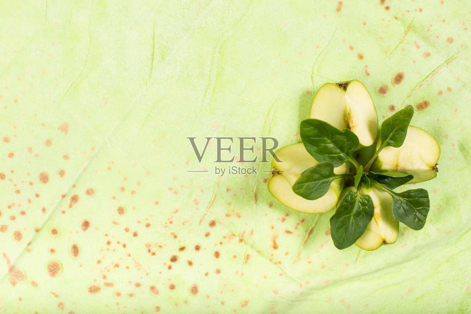 用苹果和菠菜叶做成的玉米饼。绿颜色的亚美尼亚式面包。照片摄影图片