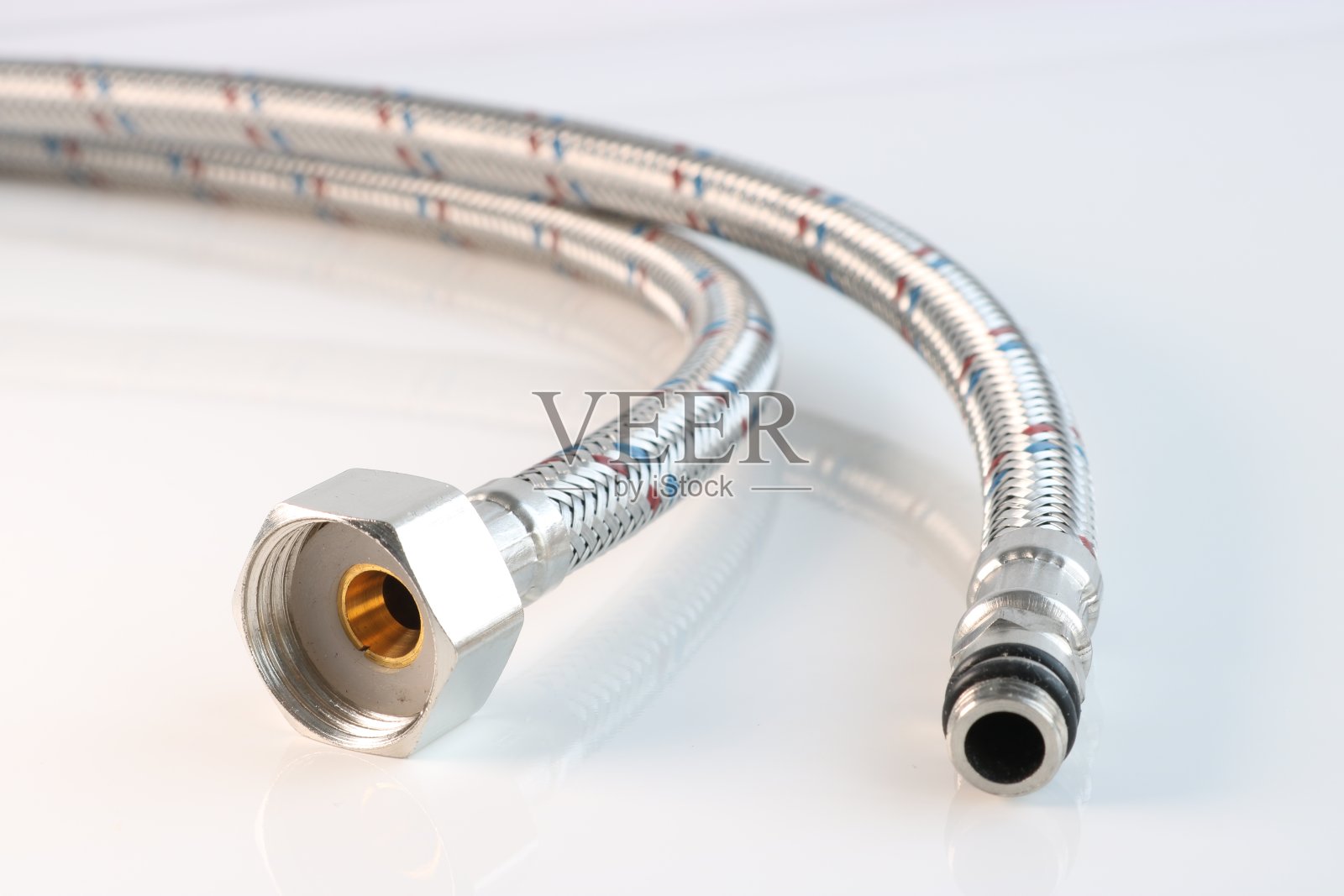 在光线背景上有连接的柔性水管。管道配件。照片摄影图片