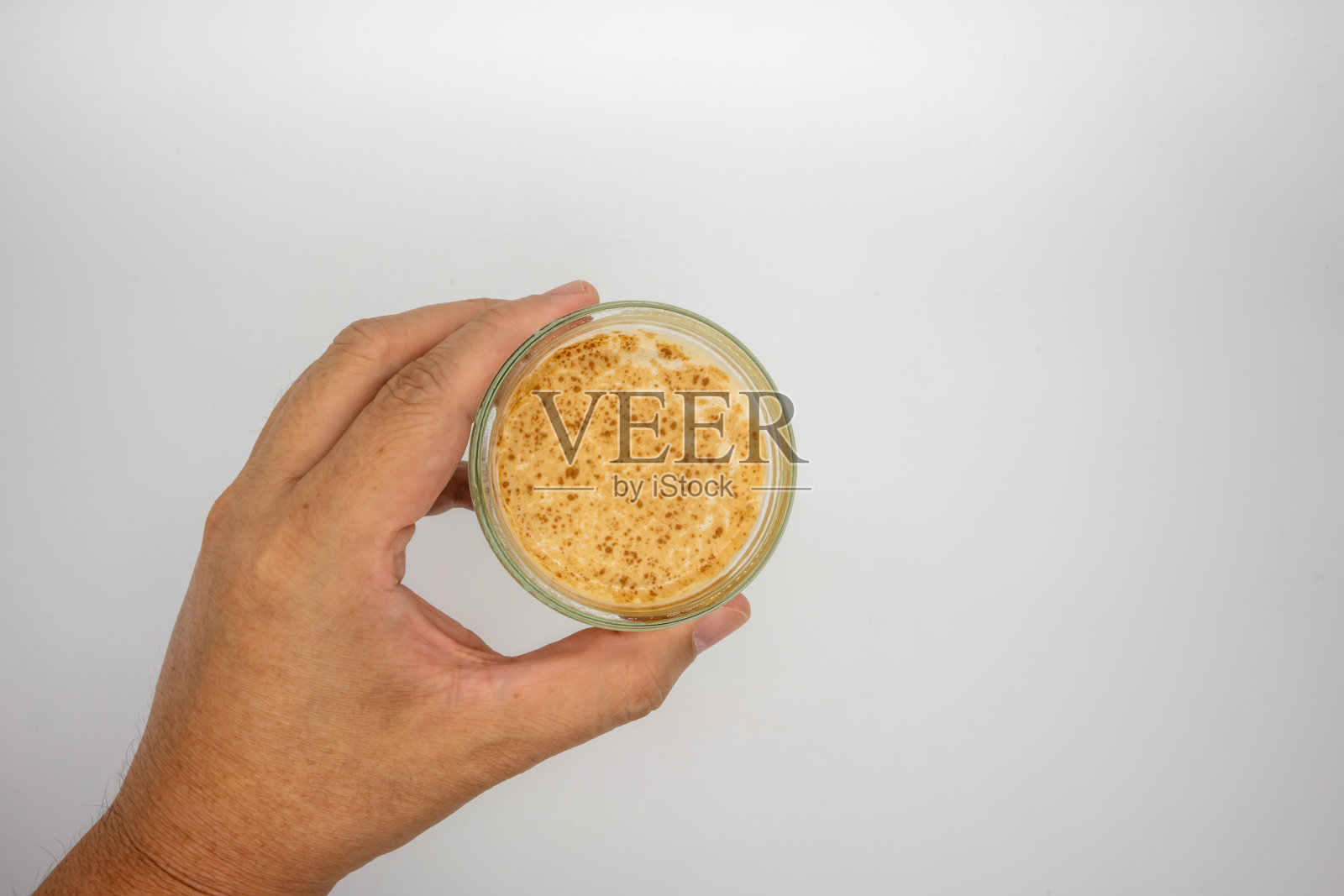 手拿脏咖啡在冷牛奶上孤立在白色的背景。照片摄影图片