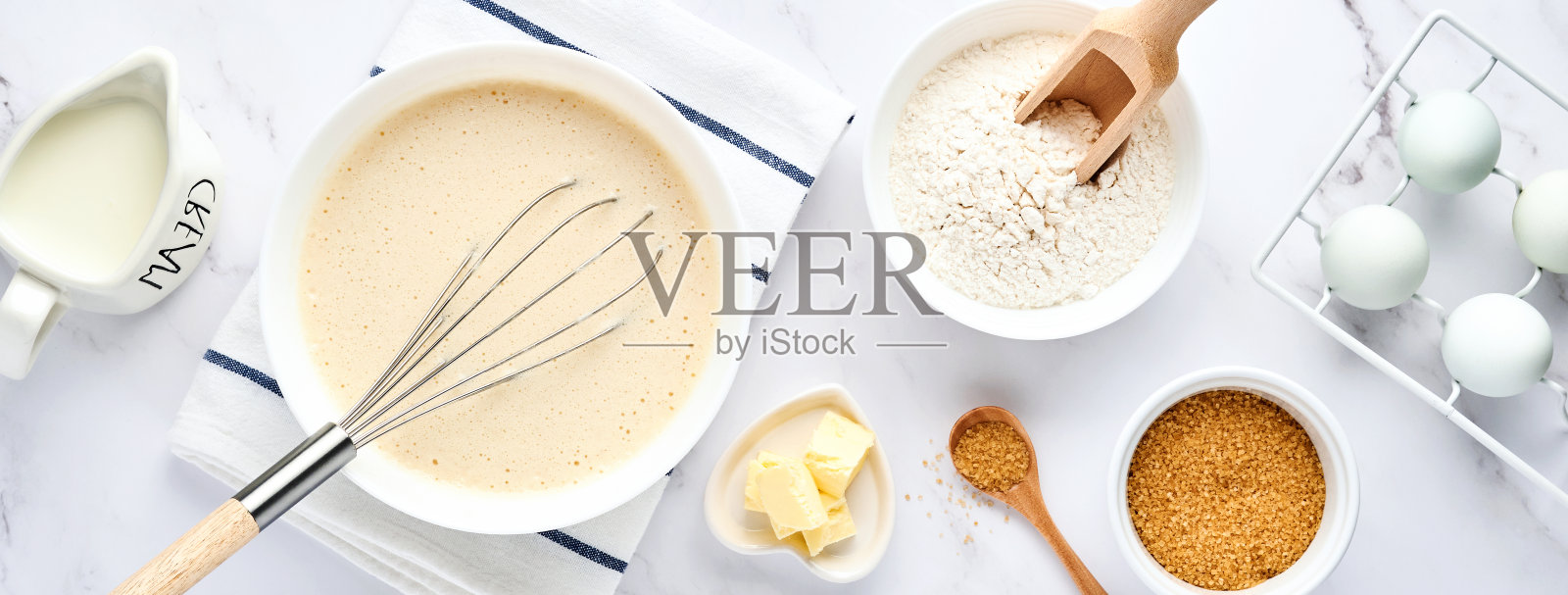 为早餐或马斯伦尼察的家庭煎饼准备面团。餐桌上的配料——面粉、鸡蛋、黄油、糖、盐、牛奶。食谱一步一步来。前视图。照片摄影图片