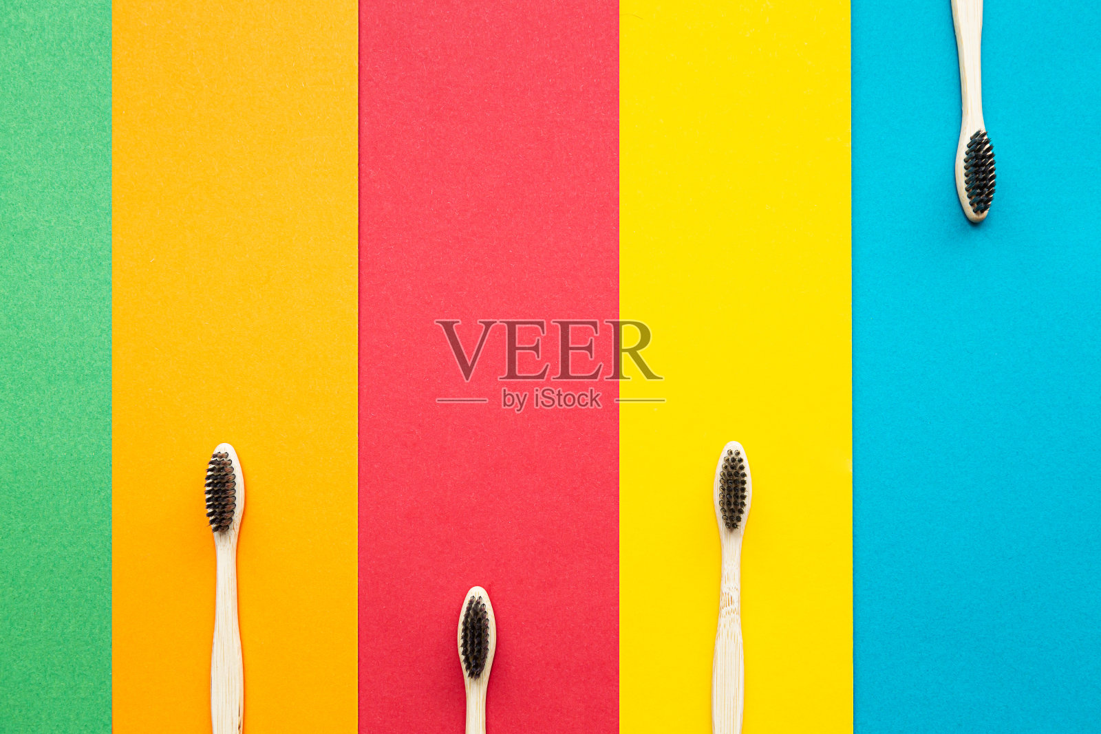 有机竹制牙刷在明亮的多色背景上组成。自然的口腔卫生。零浪费保护牙齿。照片摄影图片