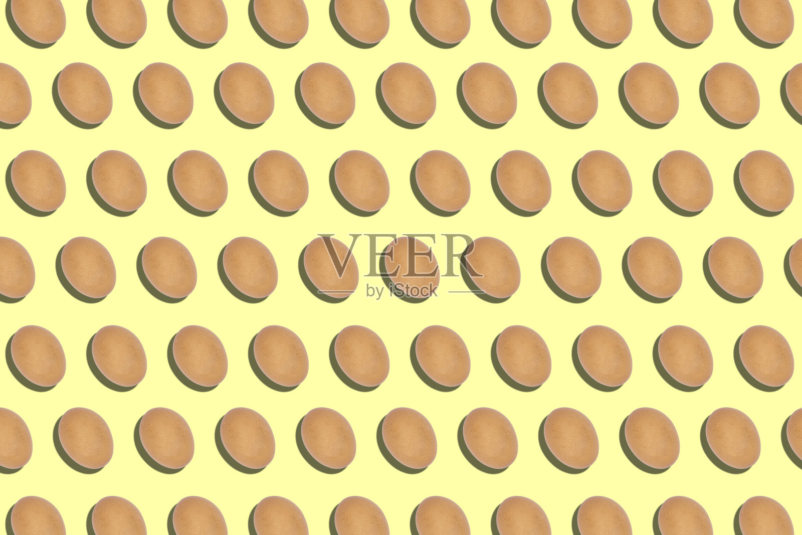 许多鸡蛋排成一行排列在黄色的背景上,生食配料的背景,艺术的背景,复活节彩蛋,图案和纹理的背景照片摄影图片