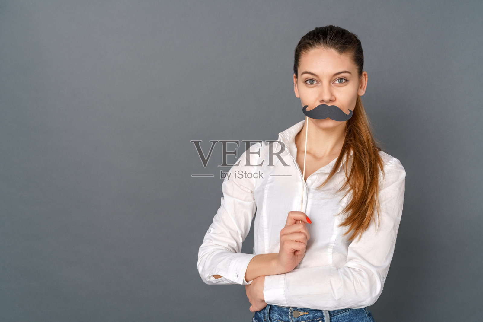 年轻女子学生工作室孤立灰色摆姿势与精心制作的胡子照片摄影图片