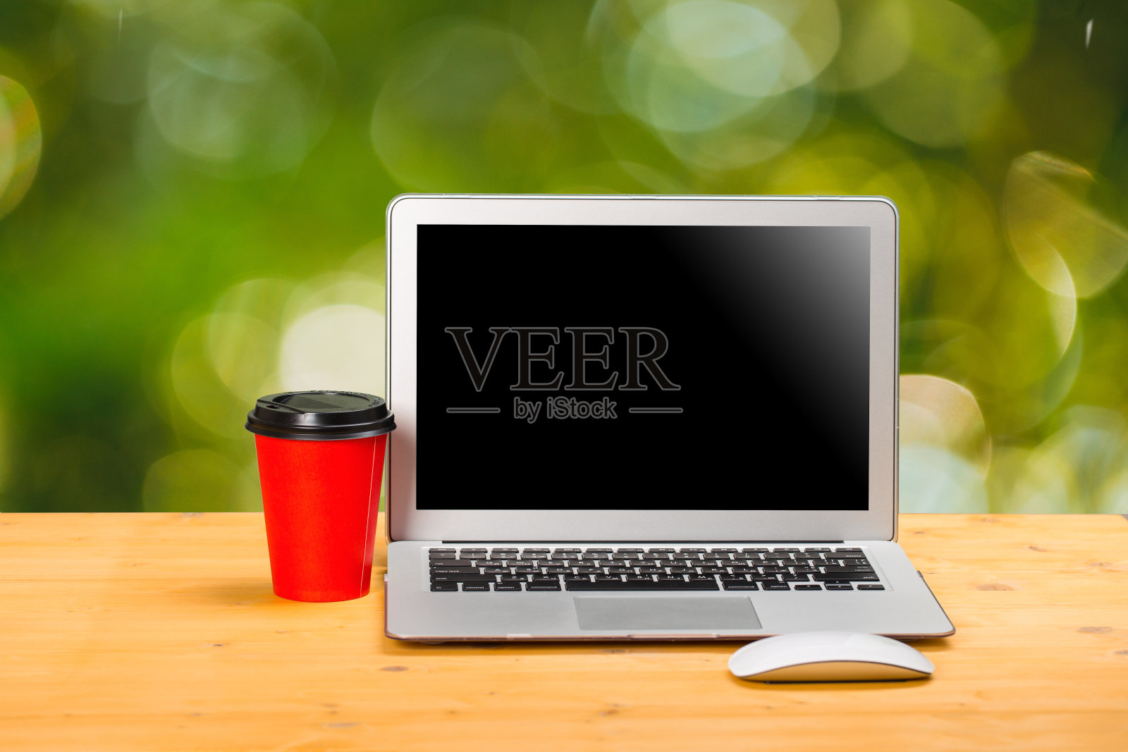 在共同工作空间的木桌上模拟空白的笔记本电脑屏幕、咖啡和电脑鼠标。照片摄影图片