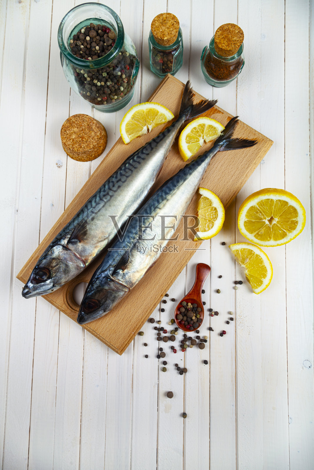 切菜板上的生鲭鱼加香料。照片摄影图片