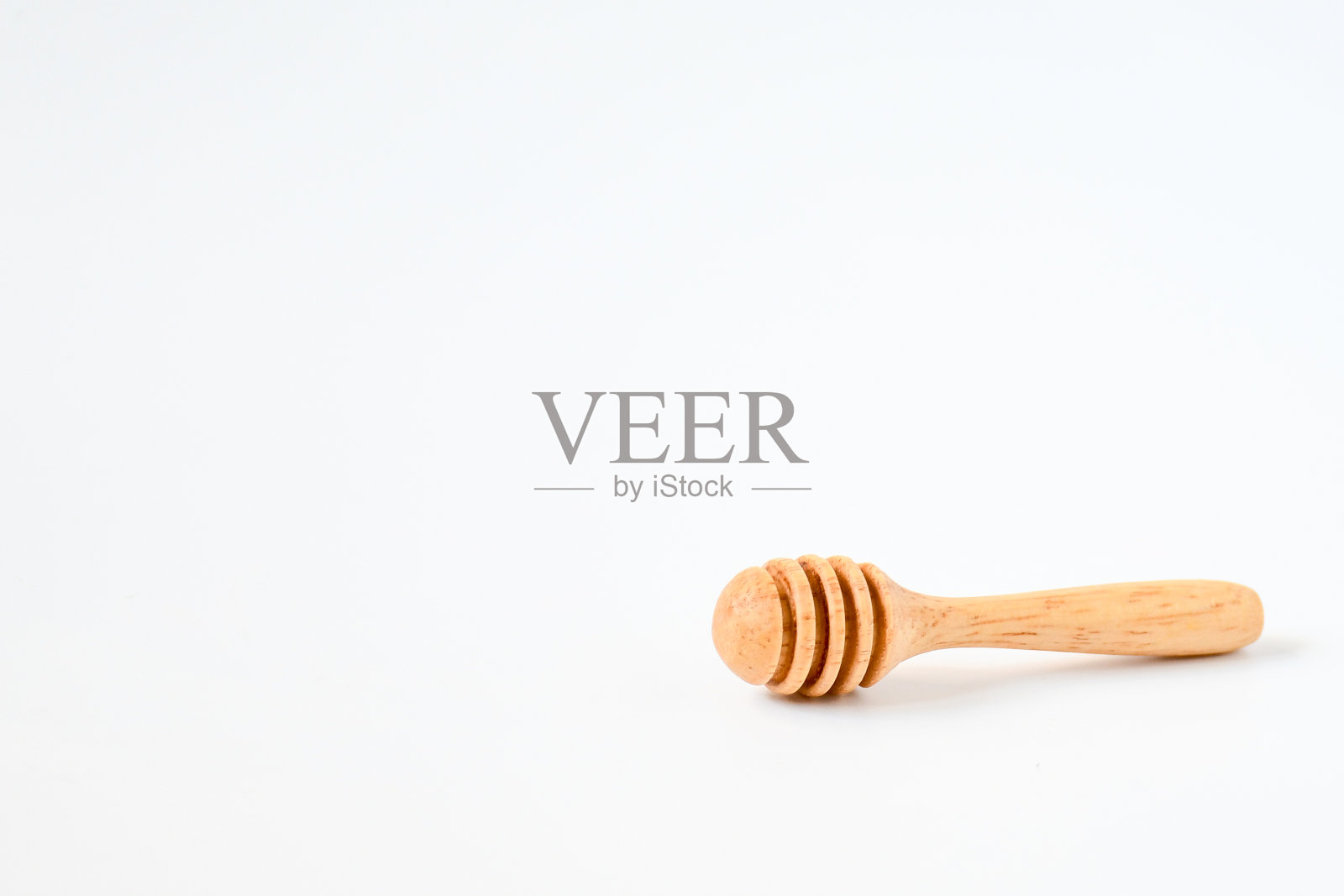 小型自然木材蜂蜜和糖浆勺棍服务器上白色的背景。照片摄影图片