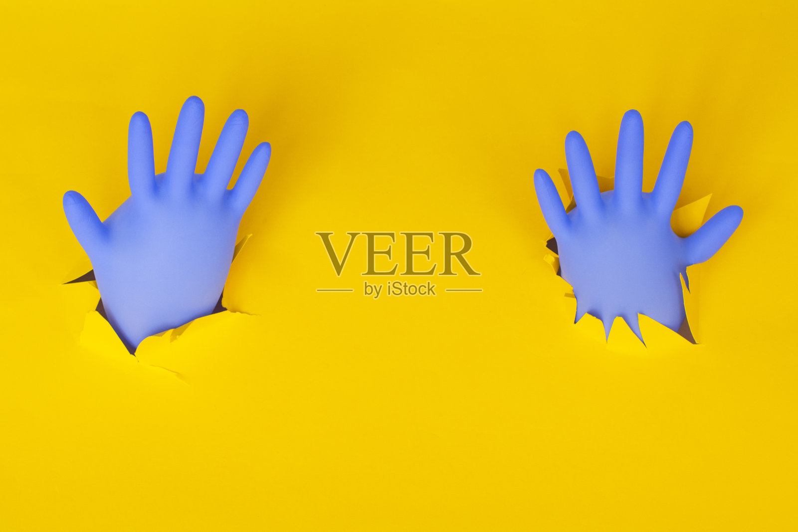 黄色背景上的蓝色蓬松手套。医疗保健的概念照片摄影图片