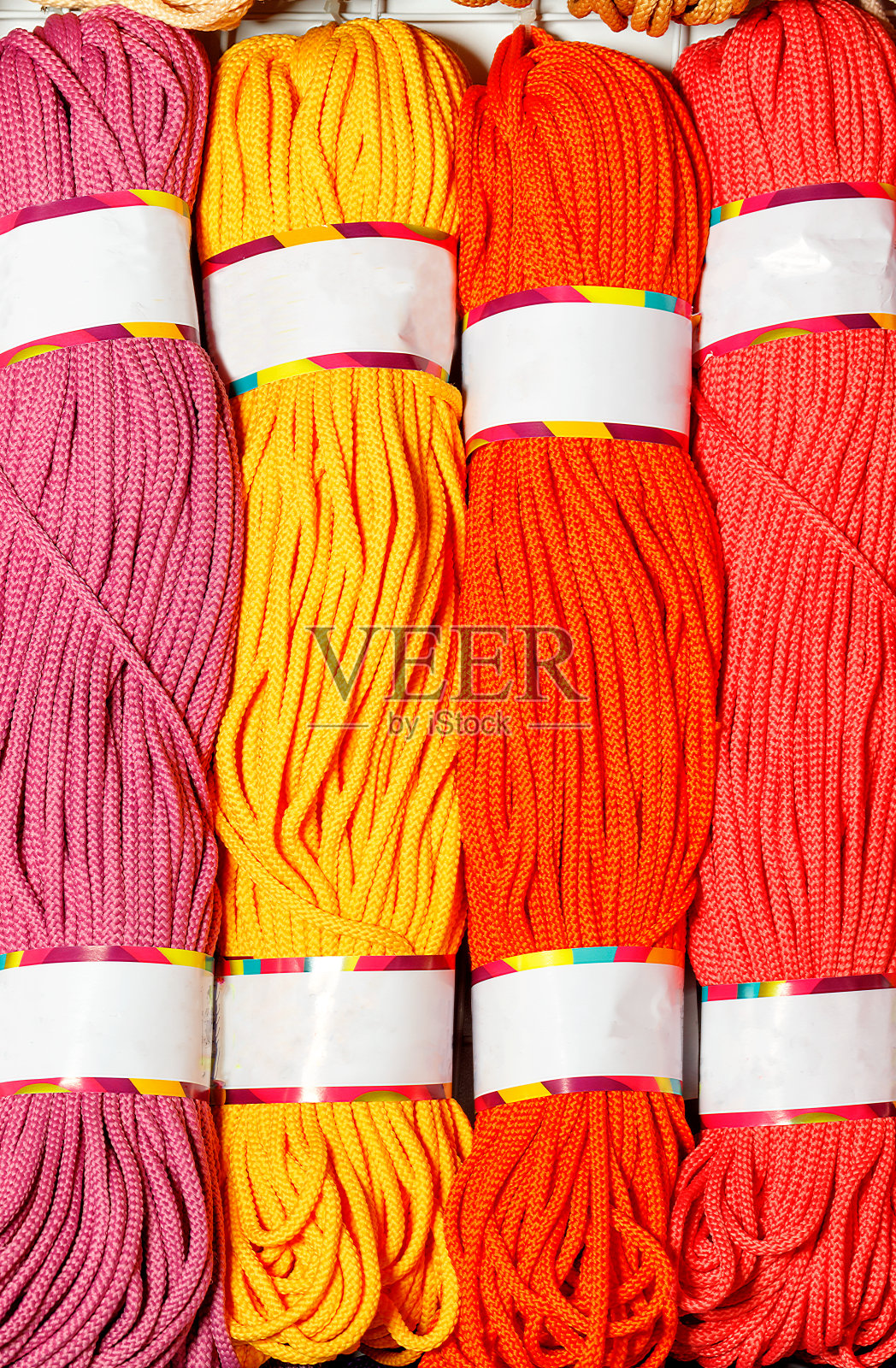 涤纶线束,有亮粉色、红色、黄色和深红色。照片摄影图片