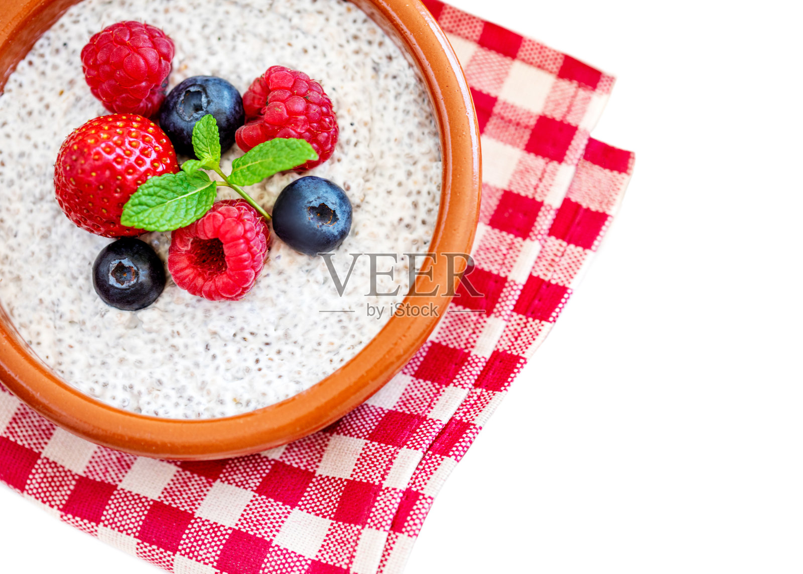 在白色背景上有孤立的水果和浆果的奇亚种子布丁。芡欧鼠尾草种子酸奶。前视图。照片摄影图片