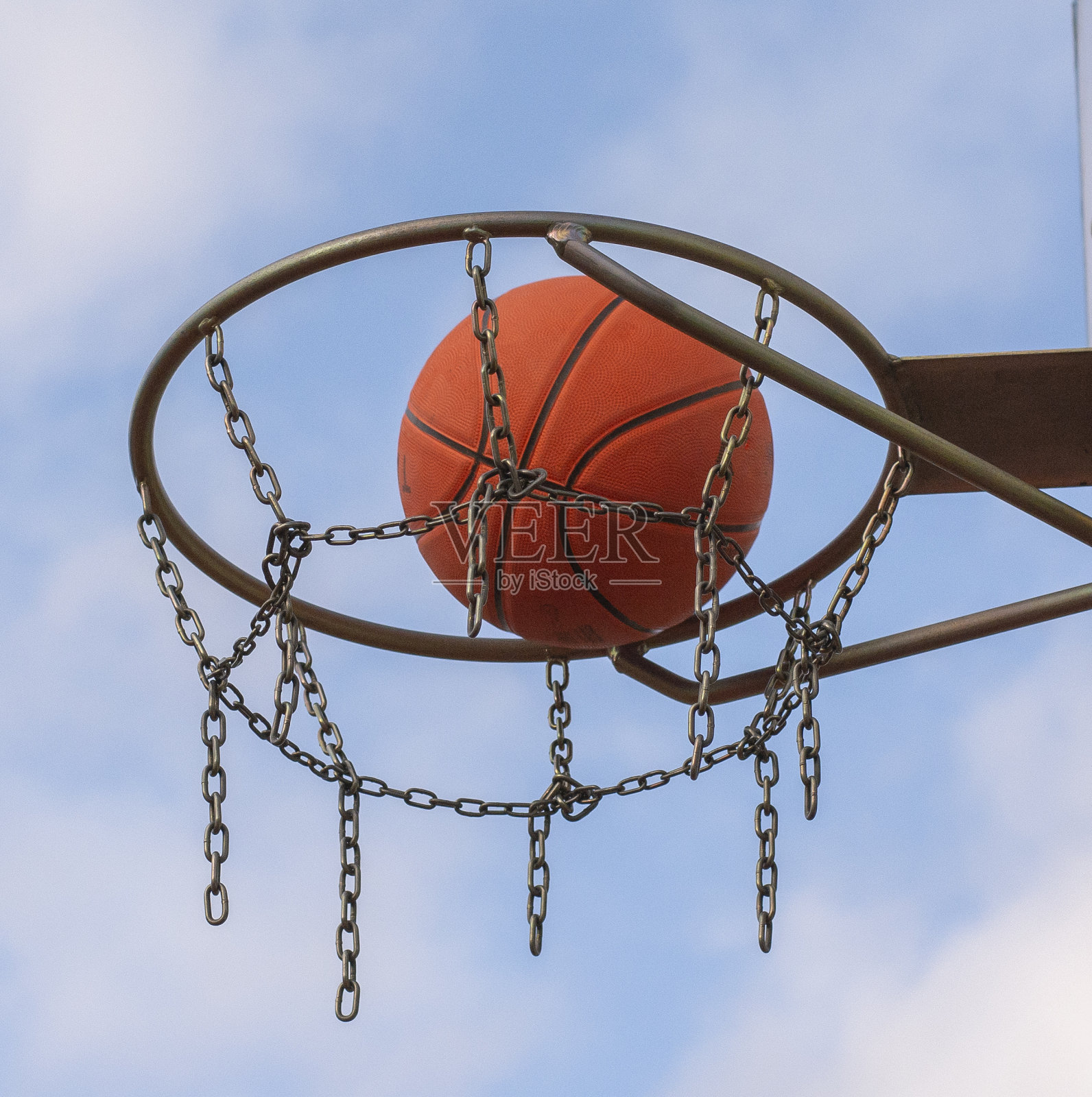 篮筐在室外公共场地。篮球穿过篮筐。照片摄影图片