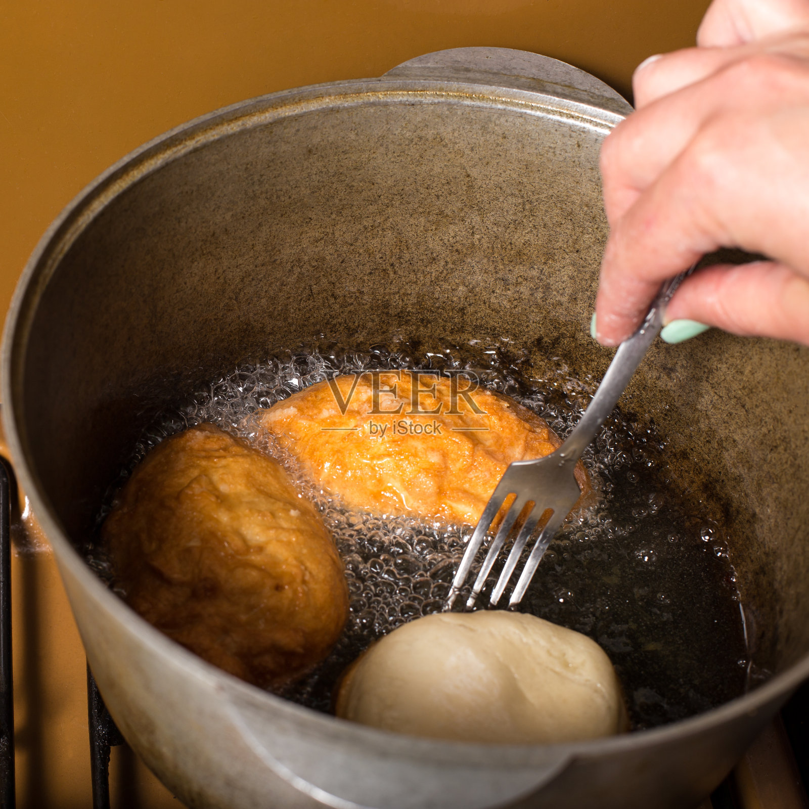 在油里炸馅饼。烹饪自制甜甜圈照片摄影图片