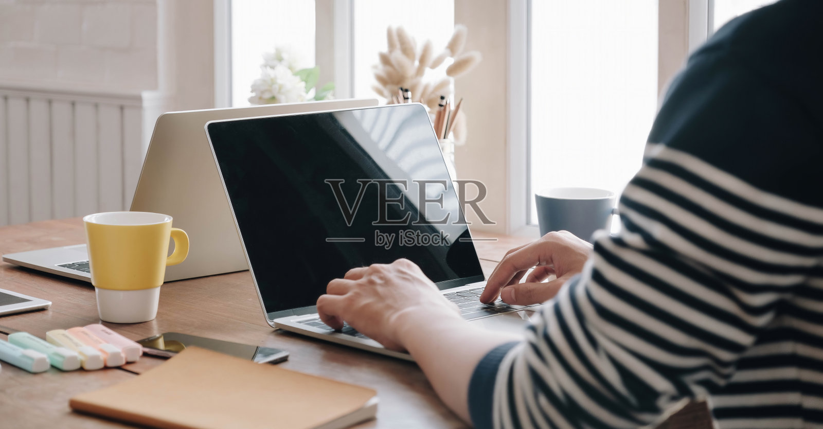 年轻的职业男性经理在办公室使用笔记本电脑的特写,商人通过便携式电脑在家工作照片摄影图片