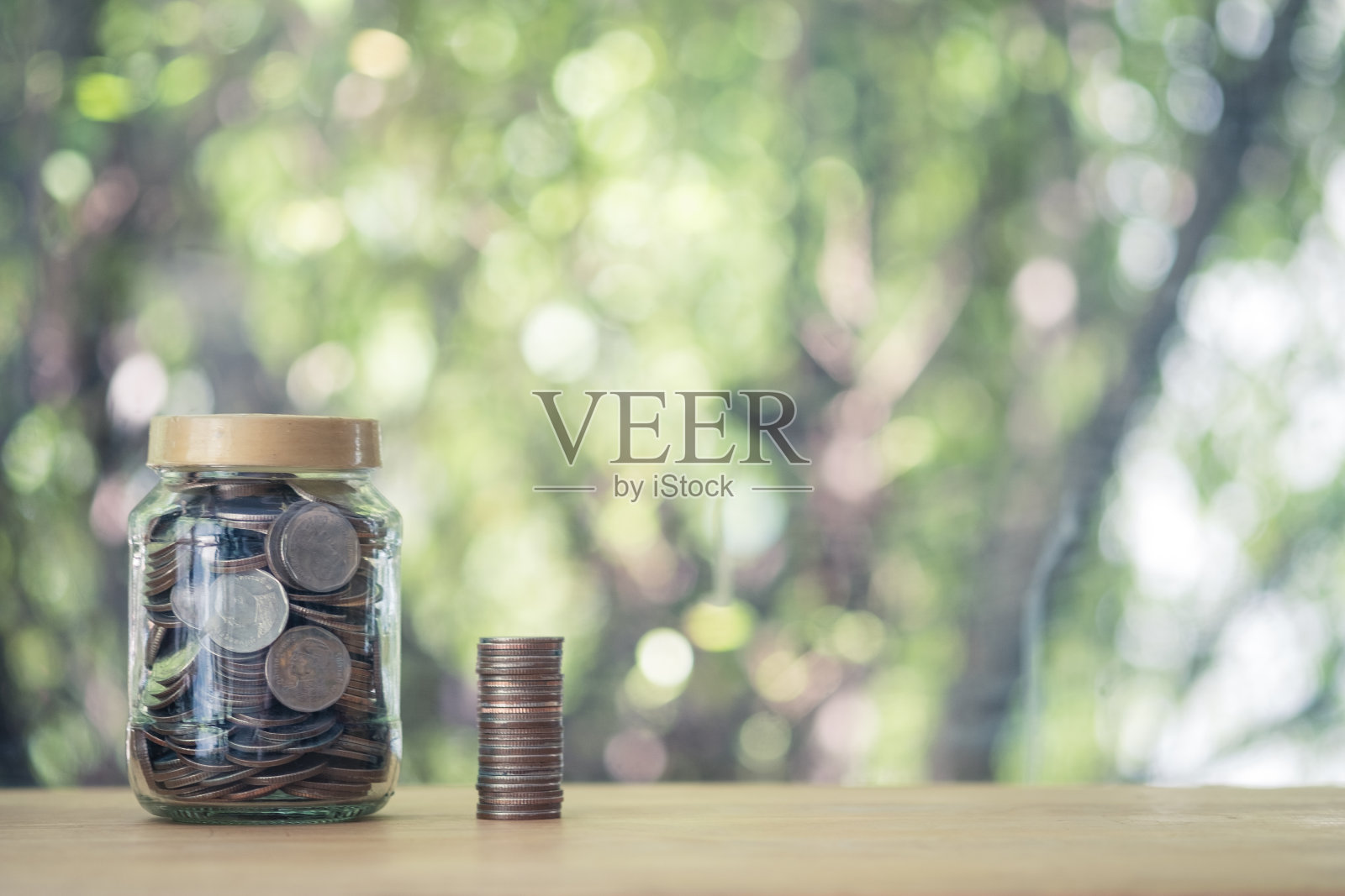 收集硬币在一个玻璃瓶泰国钱投资。存钱的概念照片摄影图片