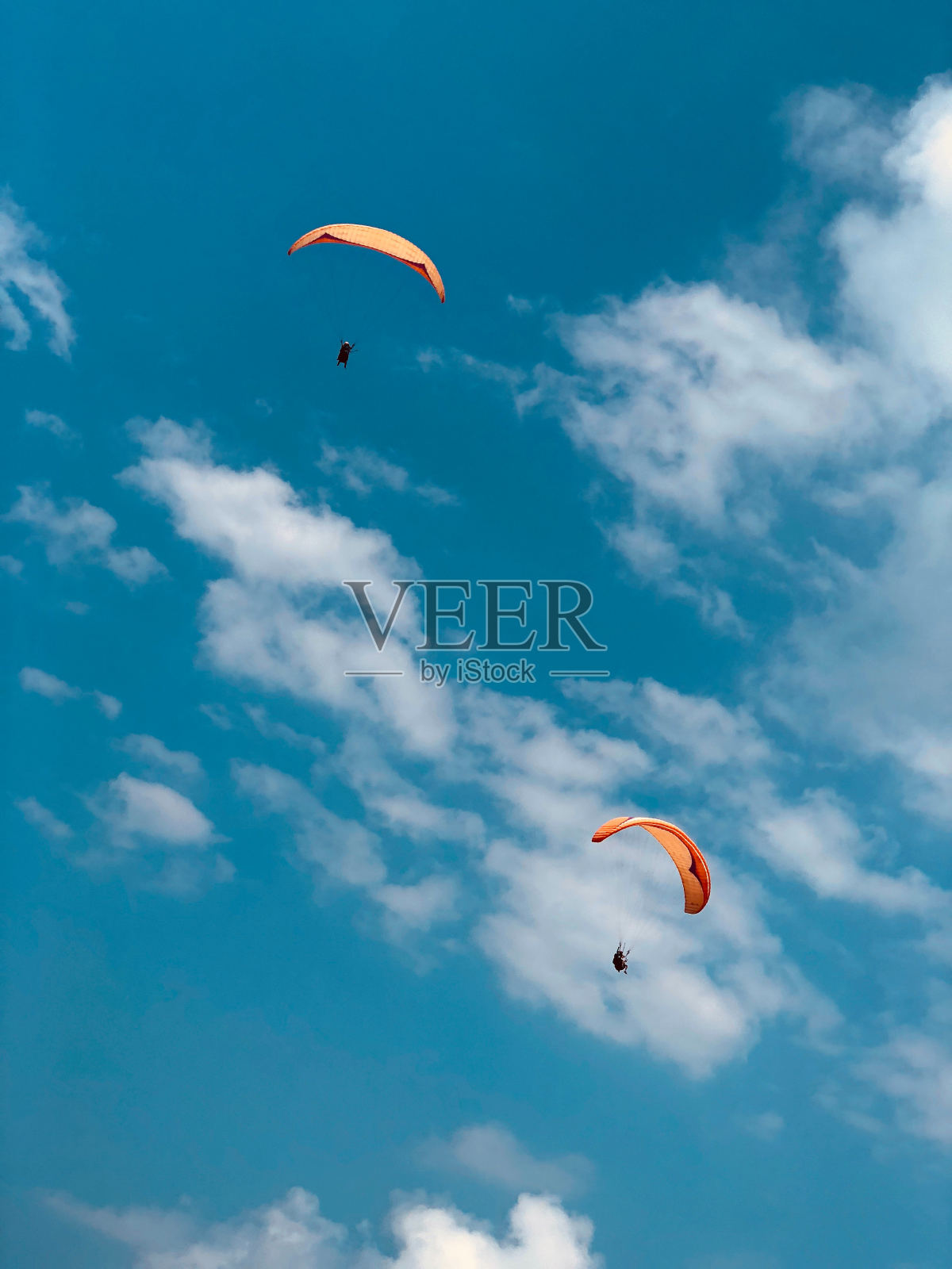 在一个晴朗的夏日里玩滑翔伞。照片摄影图片