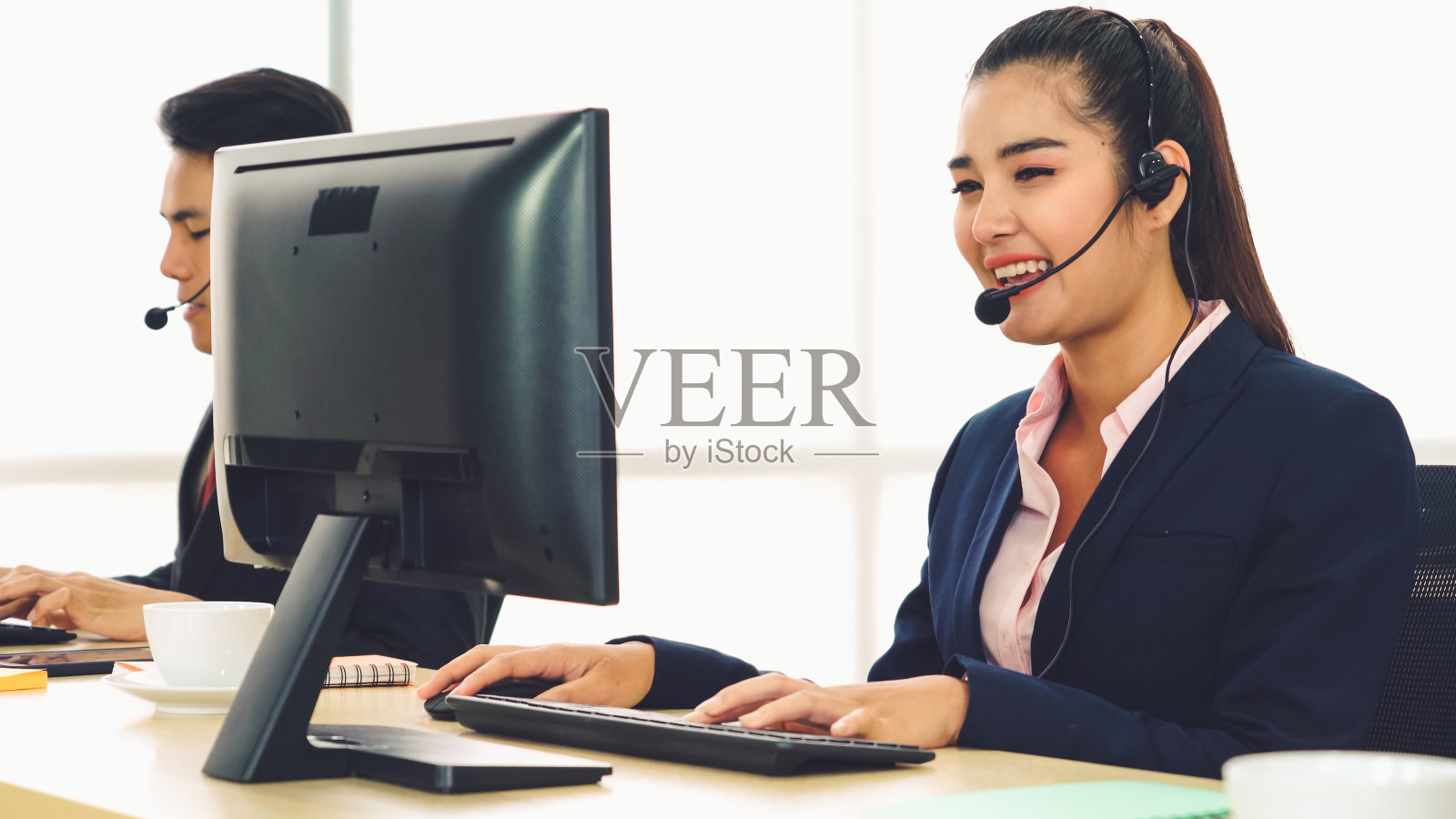 商务人员戴着耳机在办公室工作照片摄影图片