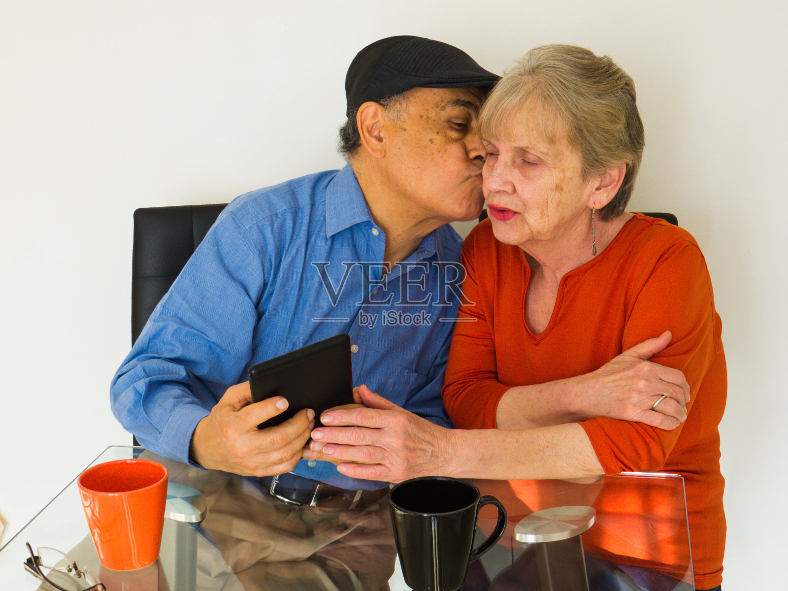 一对使用白色背景平板电脑的成熟夫妇照片摄影图片