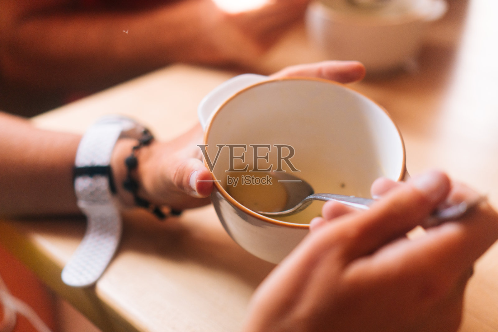 手捧一碗汤放在桌上照片摄影图片