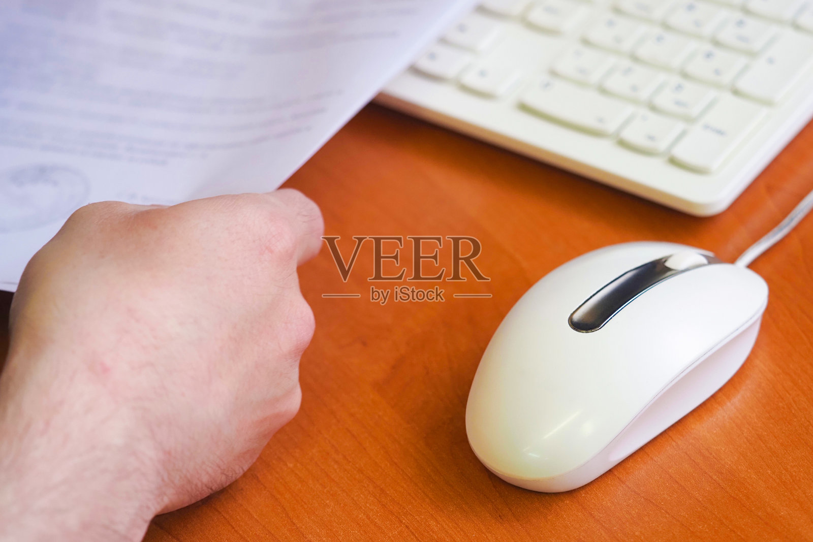 男人在办公室工作。键盘,鼠标和桌上的一叠文件照片摄影图片