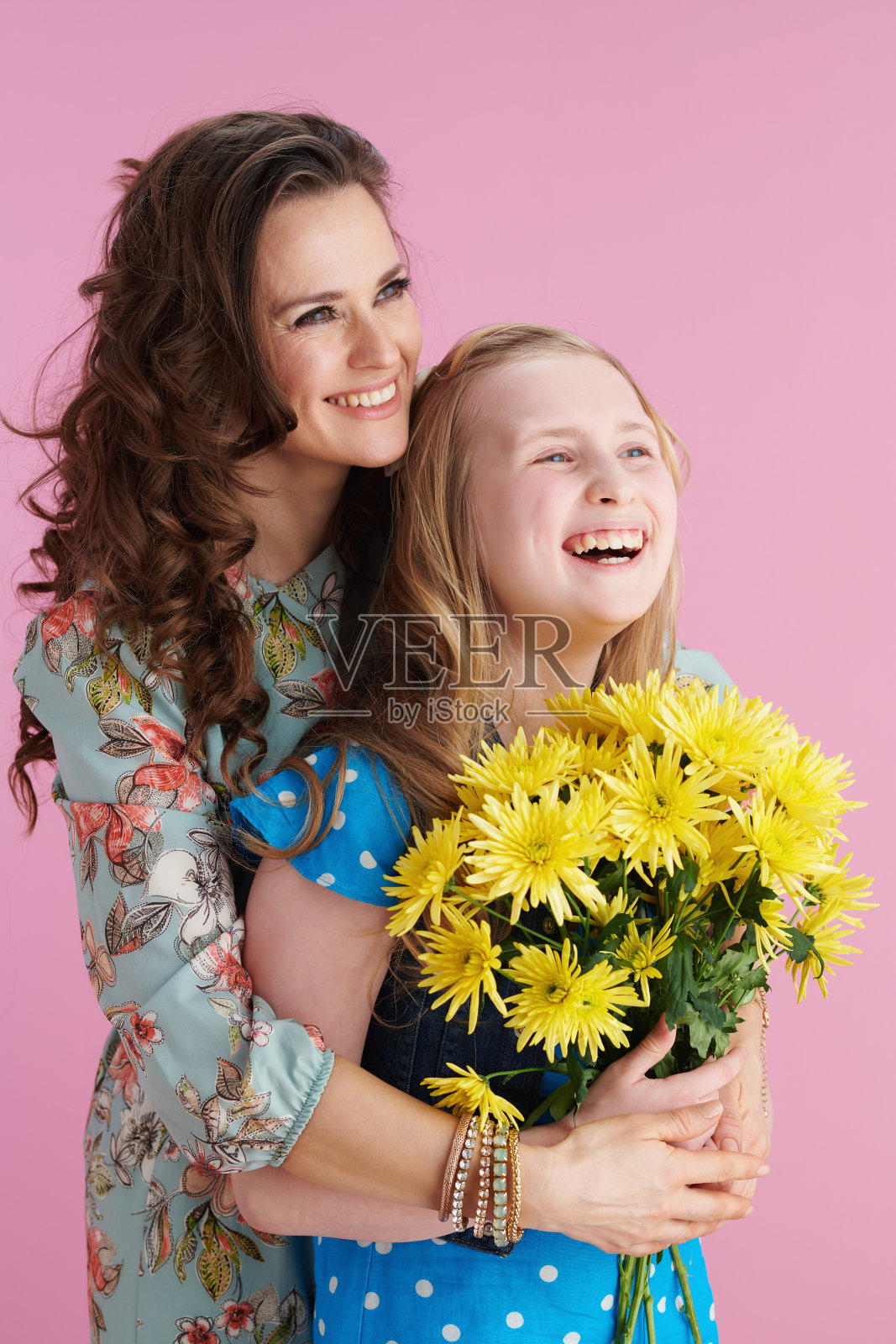 微笑着优雅的母亲和孩子拥抱在粉红色照片摄影图片