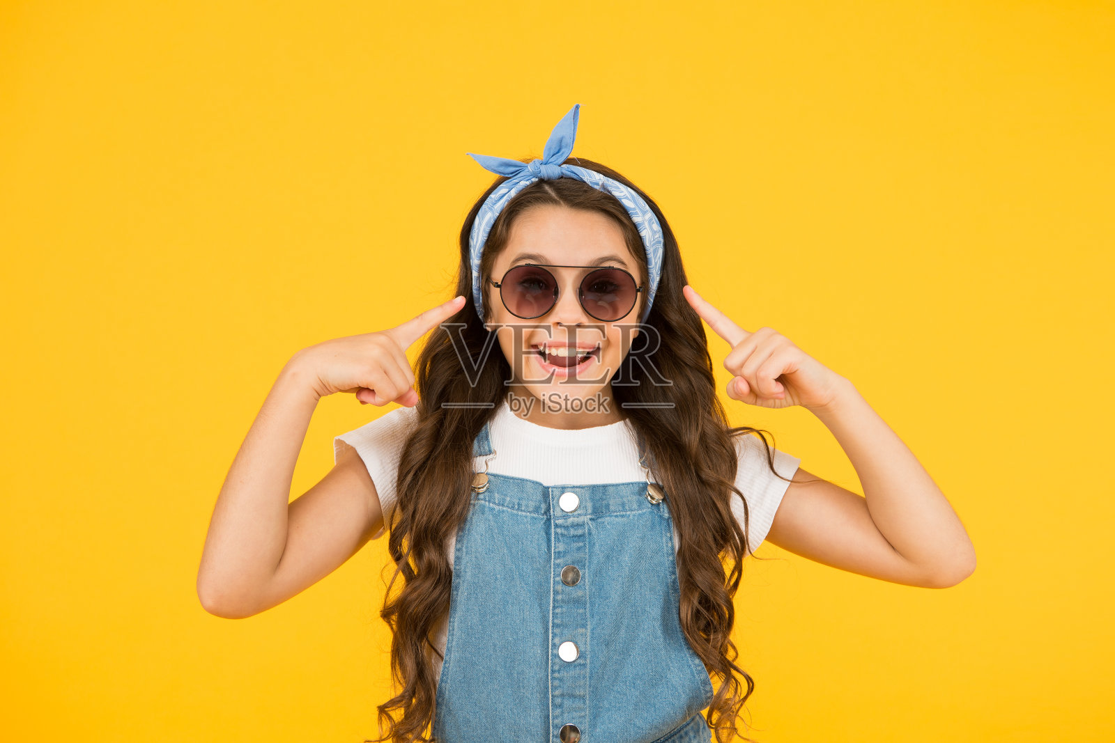 紫外线保护。女孩长卷发,太阳镜,头巾。时尚的趋势。你想要什么就穿什么吧。时尚达人。可爱的孩子时尚女孩。夏天的时尚概念照片摄影图片