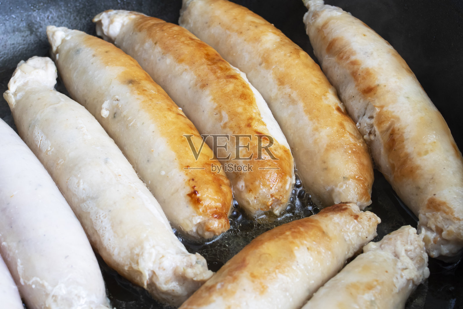 肉香肠是用平底锅煎的照片摄影图片