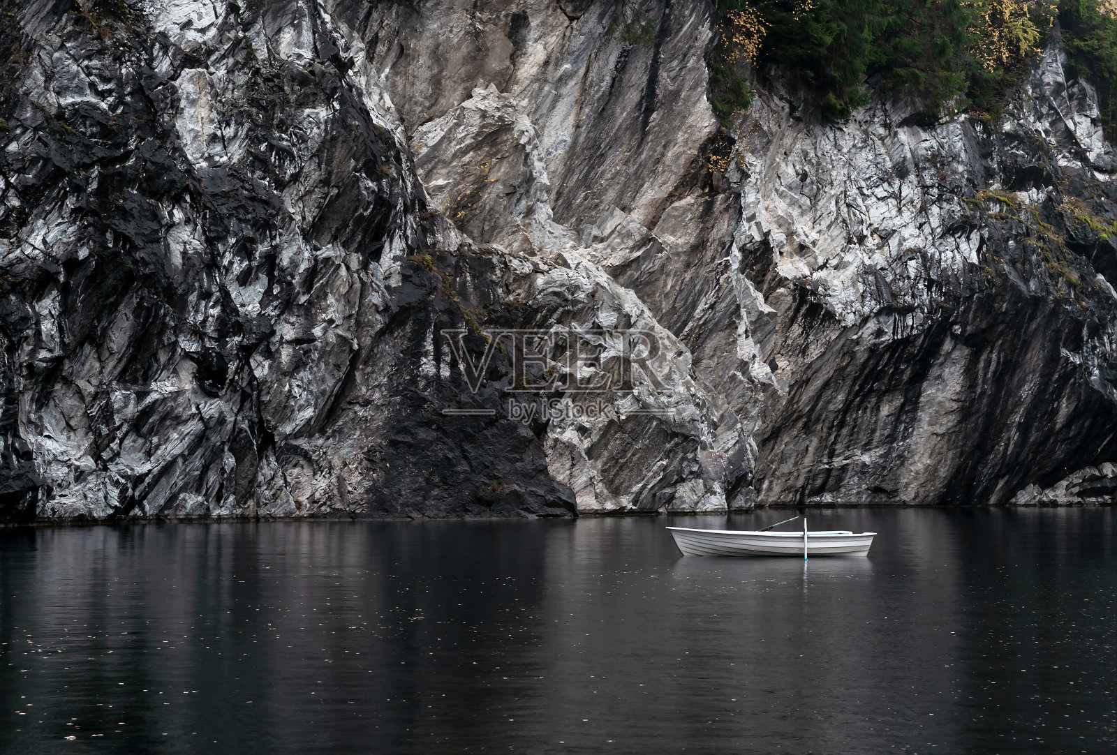 白色和绿松石船在山区湖泊自然背景。旅游和远足的概念。照片摄影图片