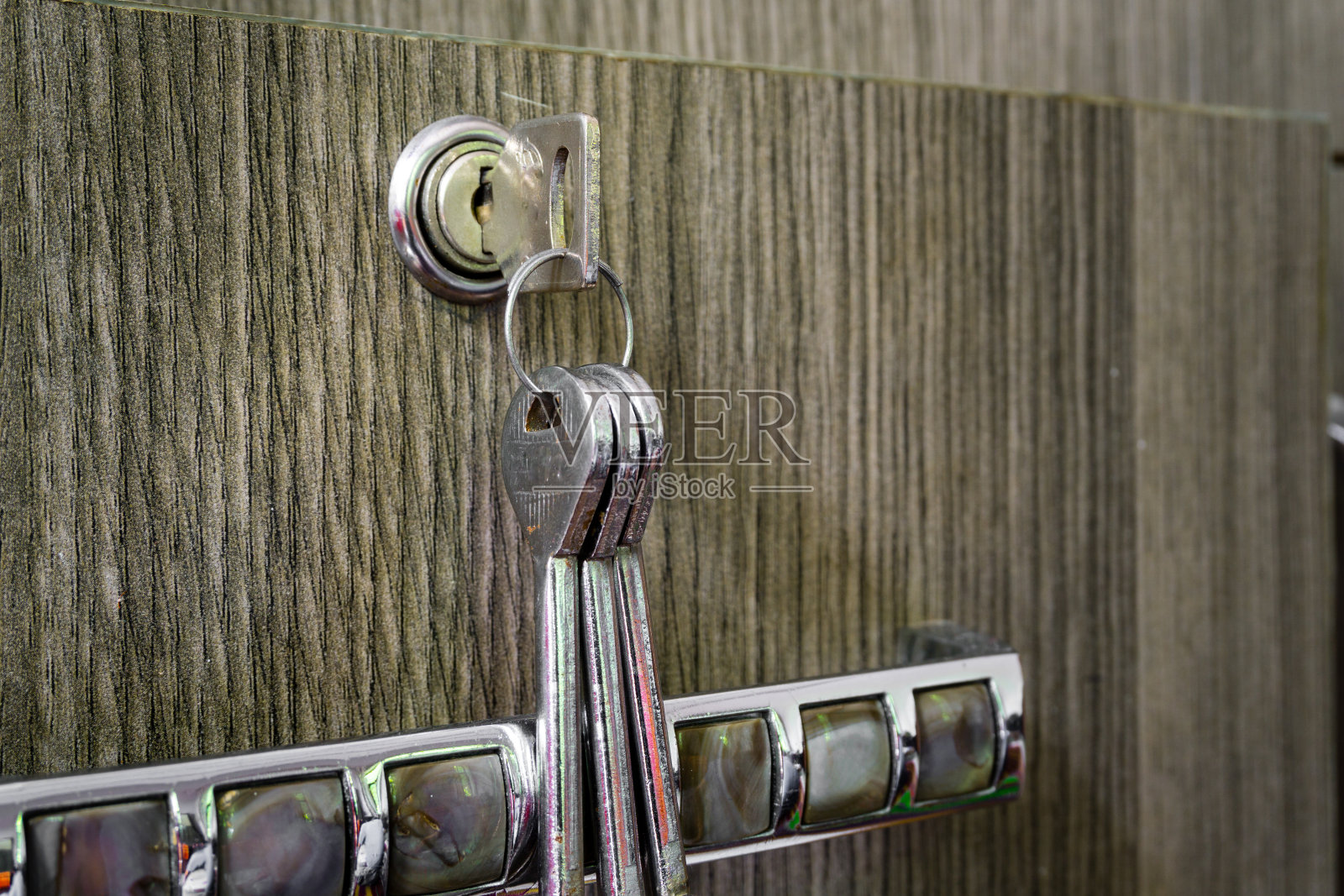 一个抽屉的特写镜头,里面有一把小锁和钥匙。照片摄影图片