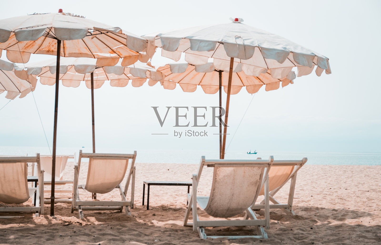 热带海滩上的躺椅和白色阳伞。沙滩上的白色雨伞照片摄影图片