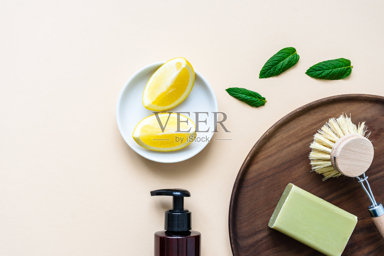 天然清洁产品与柠檬,绿色肥皂和刷子在米色背景照片摄影图片