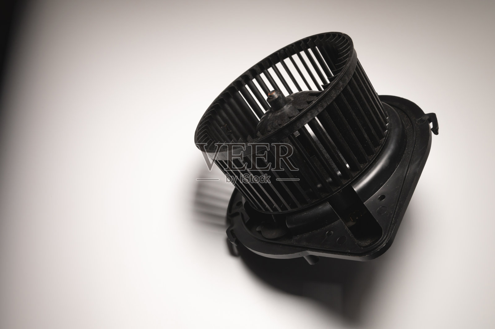 加热器马达。灰色背景上的汽车加热系统备件照片摄影图片