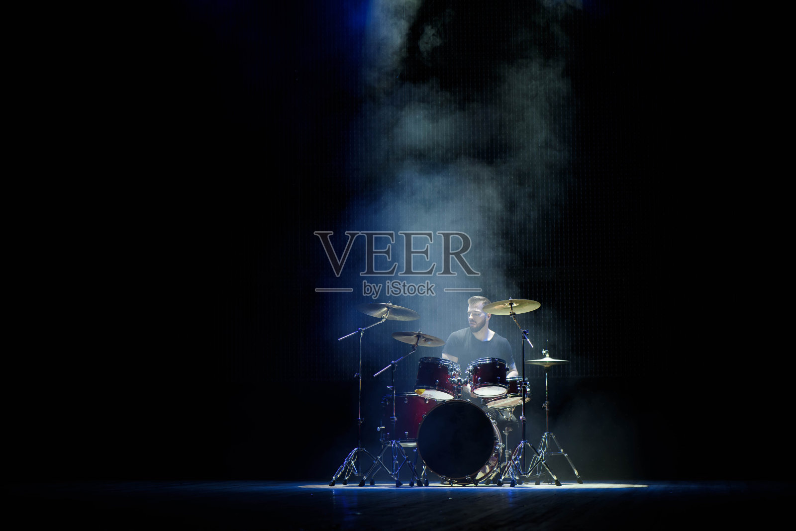 音乐,人,乐器和娱乐概念-男性音乐家用鼓槌在舞台上打鼓照片摄影图片