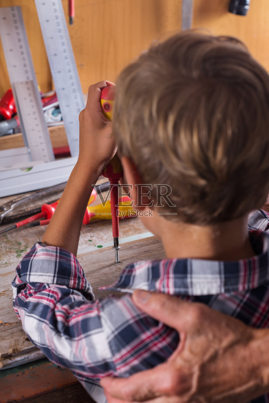 爷爷教男孩用细木工工具在长凳上工作照片摄影图片