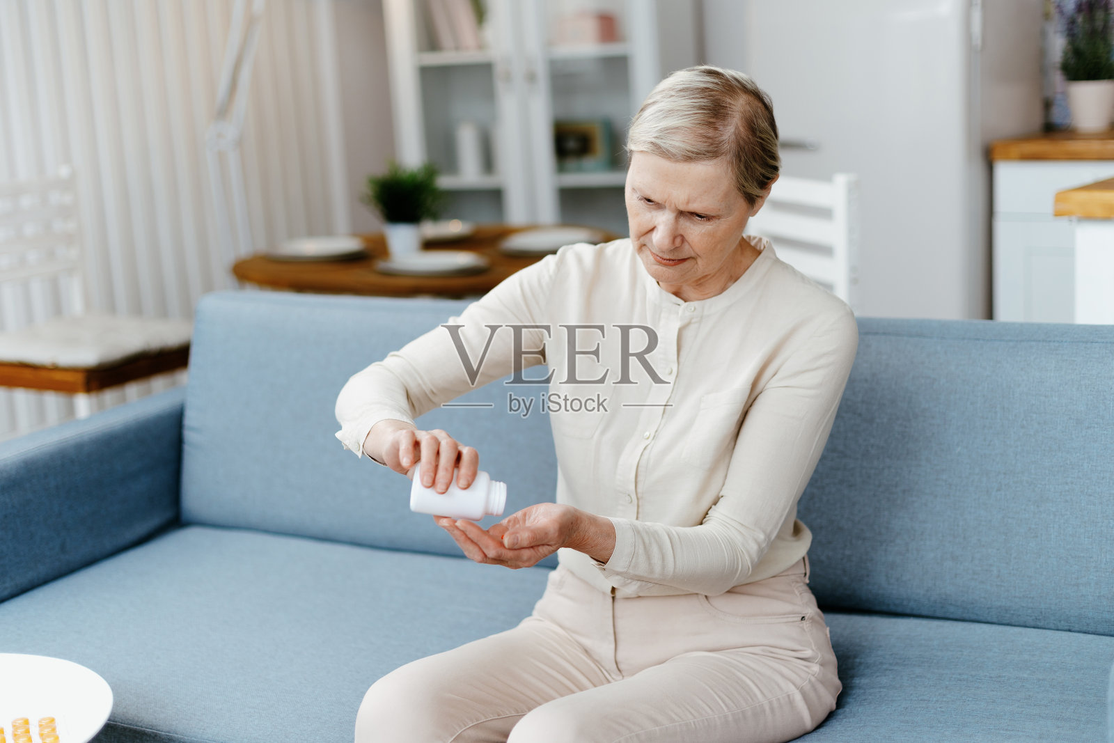 老妇人看着手里的药片照片摄影图片