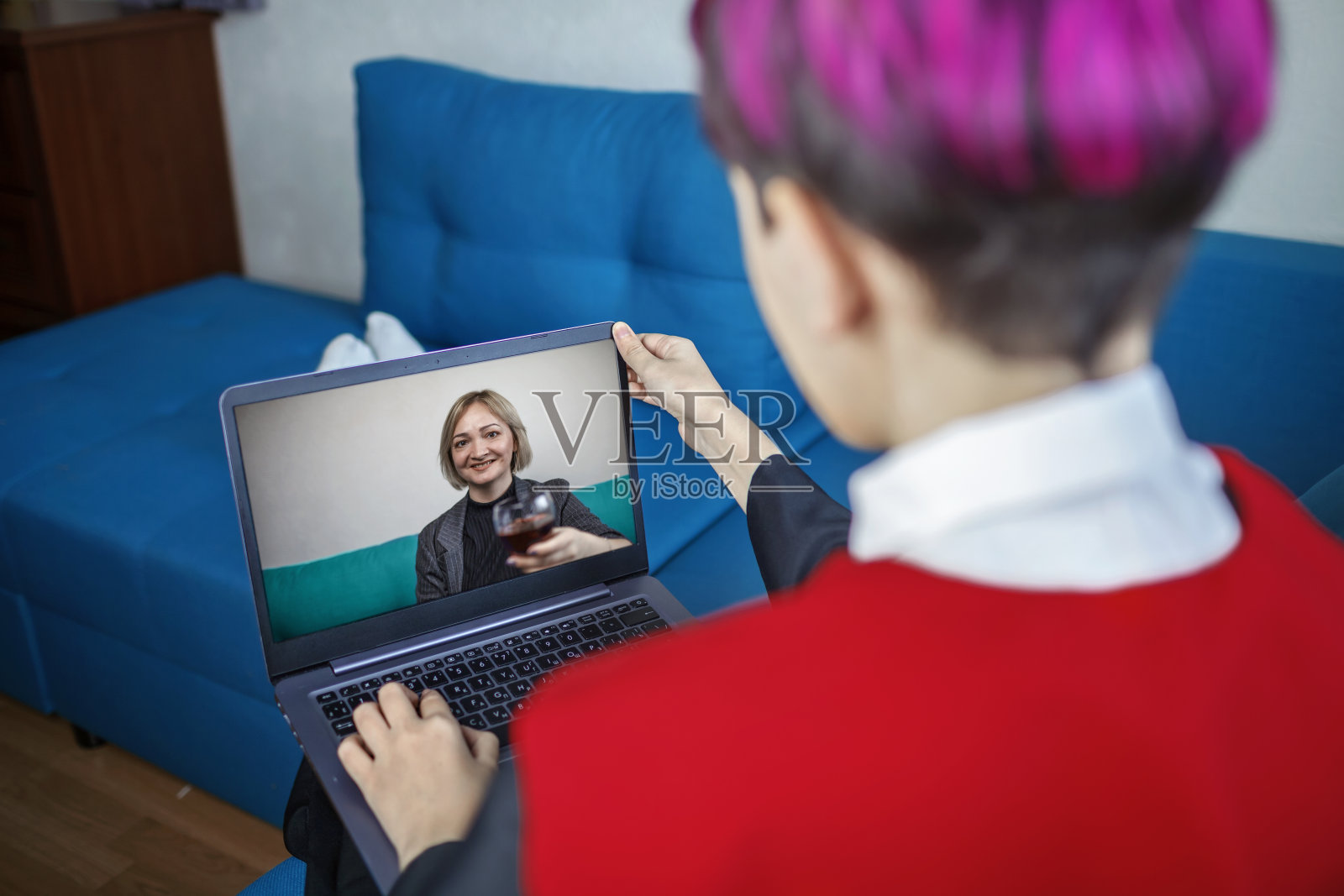 虚拟的毕业典礼。学生在网上视频通话中收到母亲的祝贺照片摄影图片