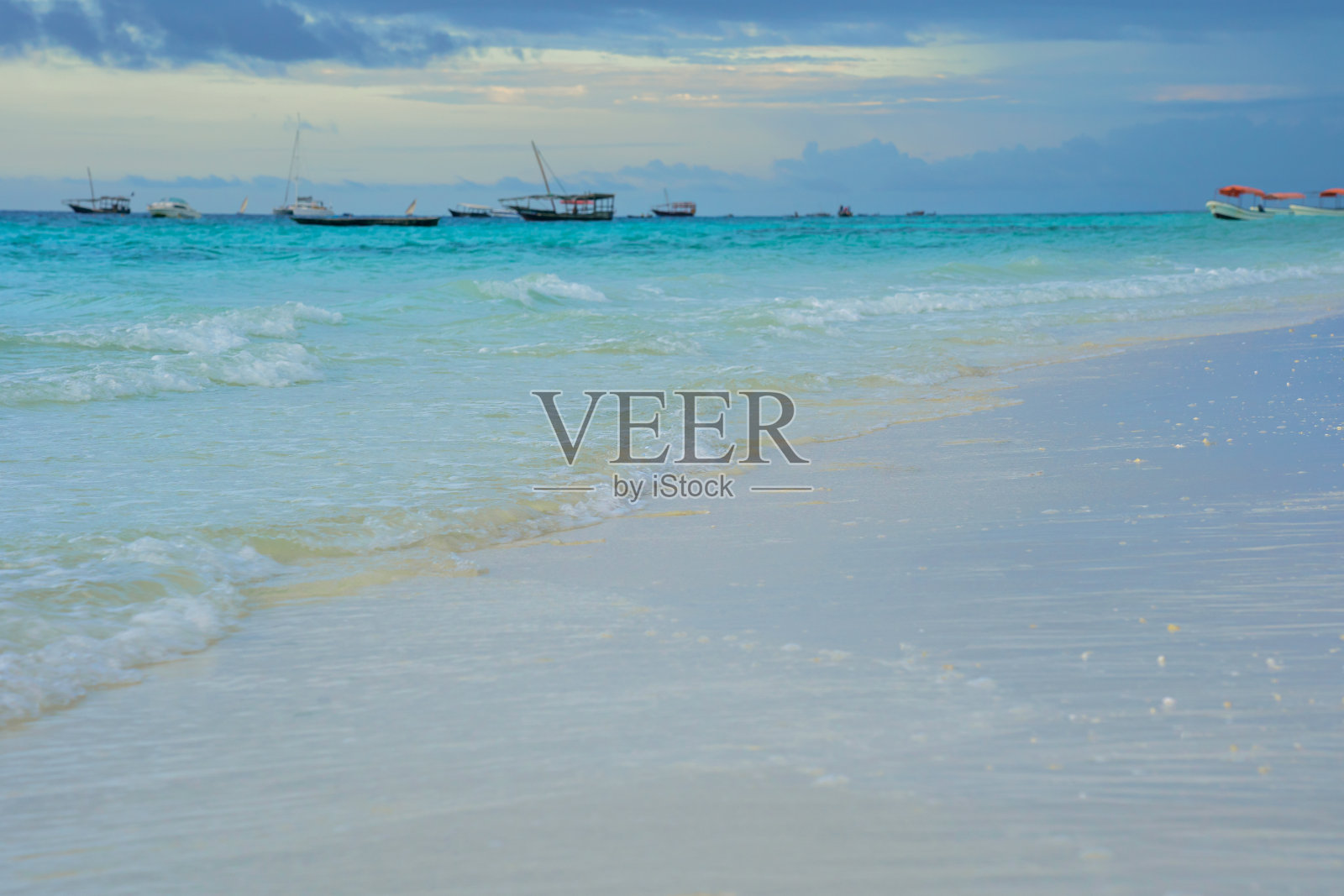 明亮的蓝色海洋和地平线上的小船和清晨白色的沙滩照片摄影图片