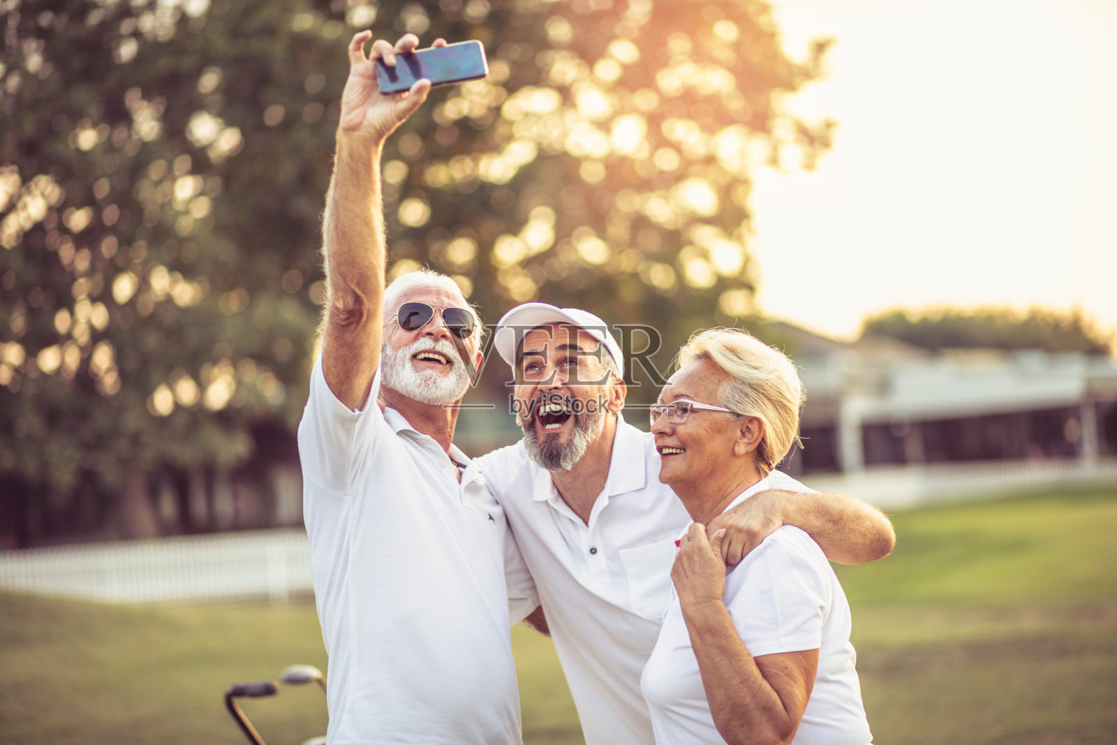 资深高尔夫球手使用手机和自拍。照片摄影图片