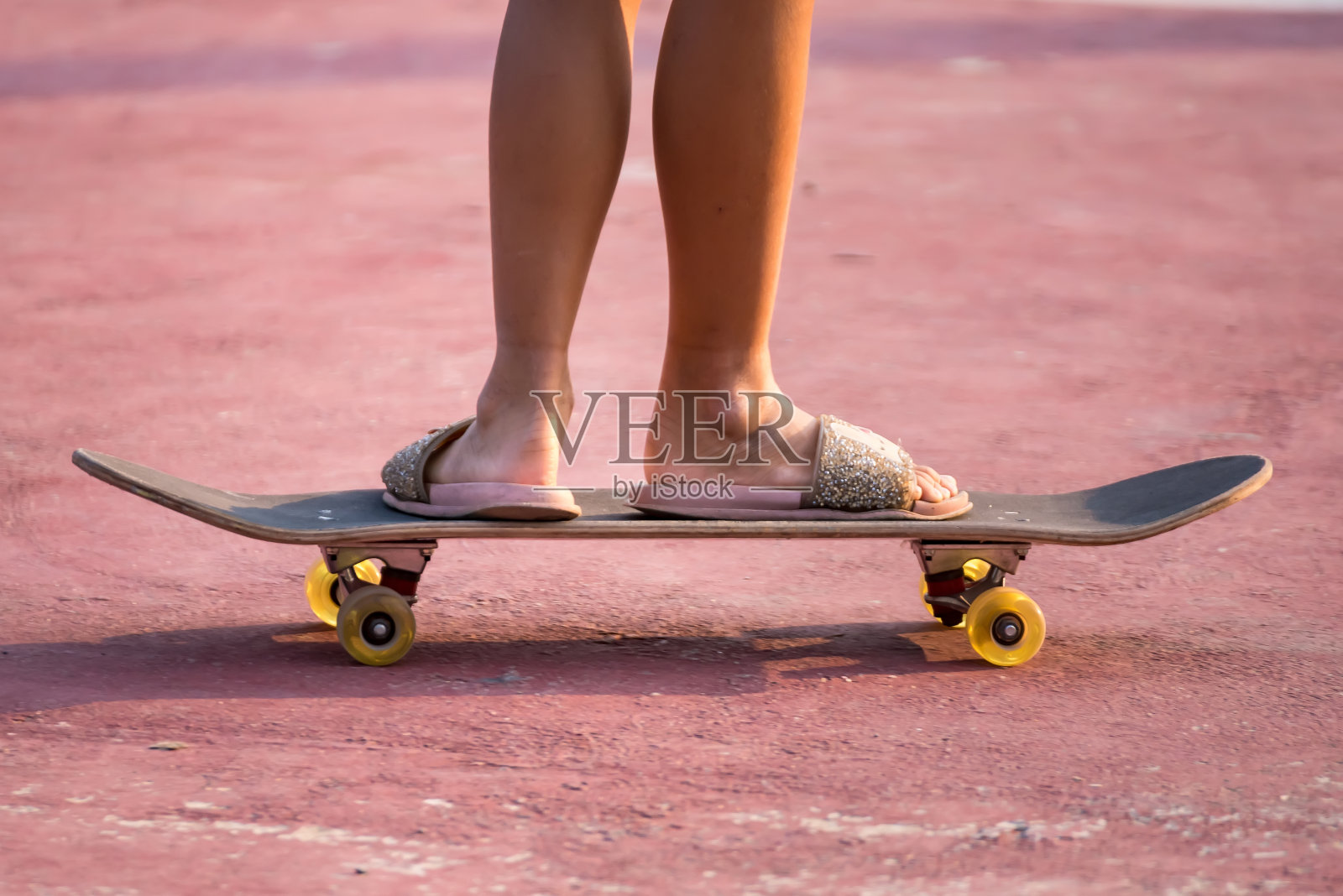 特写亚洲女孩冲浪滑冰或滑板户外在美丽的夏天。快乐的年轻女孩玩冲浪滑冰在日落时间在曼谷,泰国公园照片摄影图片