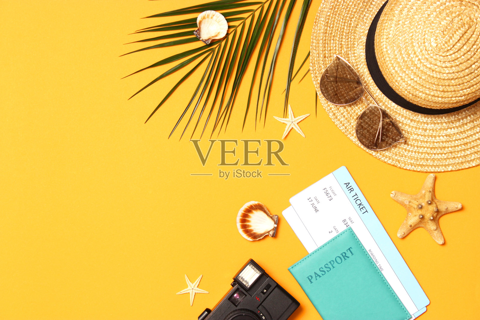 旅行配件和热带树叶上的彩色背景俯视图。照片摄影图片