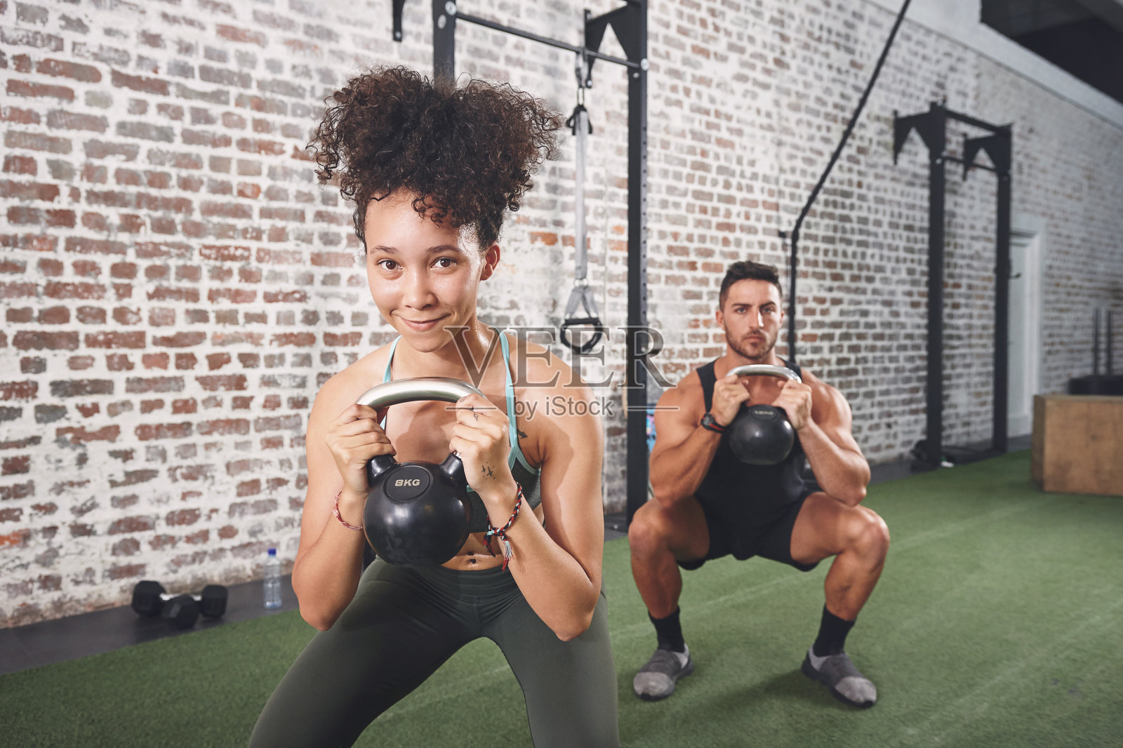 这是两个运动的年轻人在健身房用壶铃锻炼的照片照片摄影图片