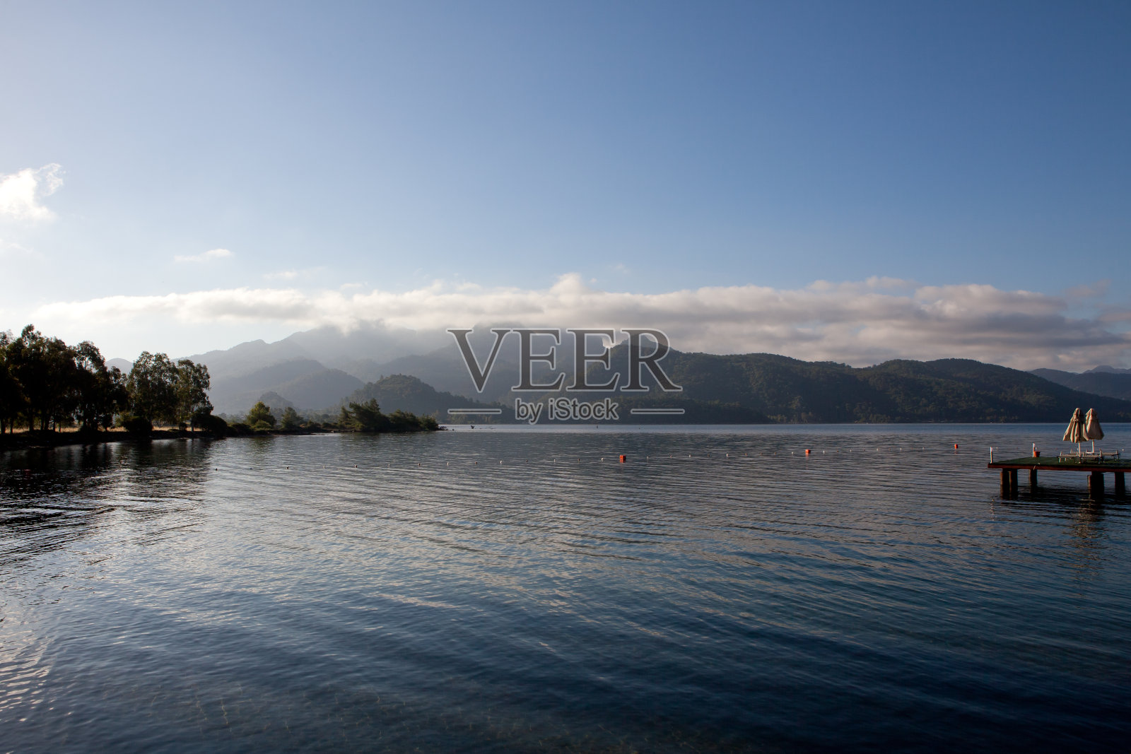 在一个阳光明媚的日子,群山之间的大海照片摄影图片